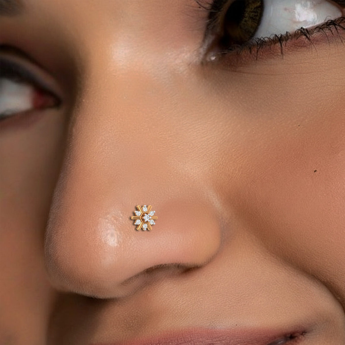 Close-up of a person wearing a gold nose pin with a small diamond-like stone.
