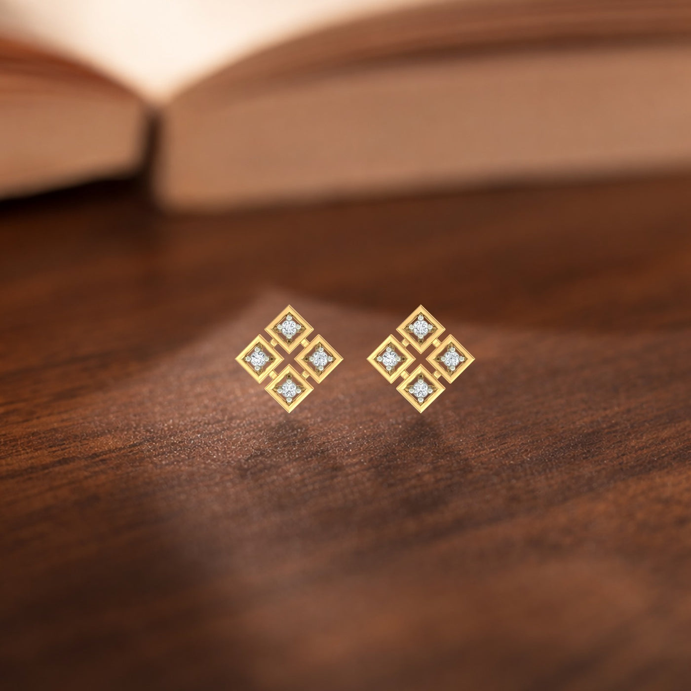 Gold and diamond stud earrings on a wooden surface.