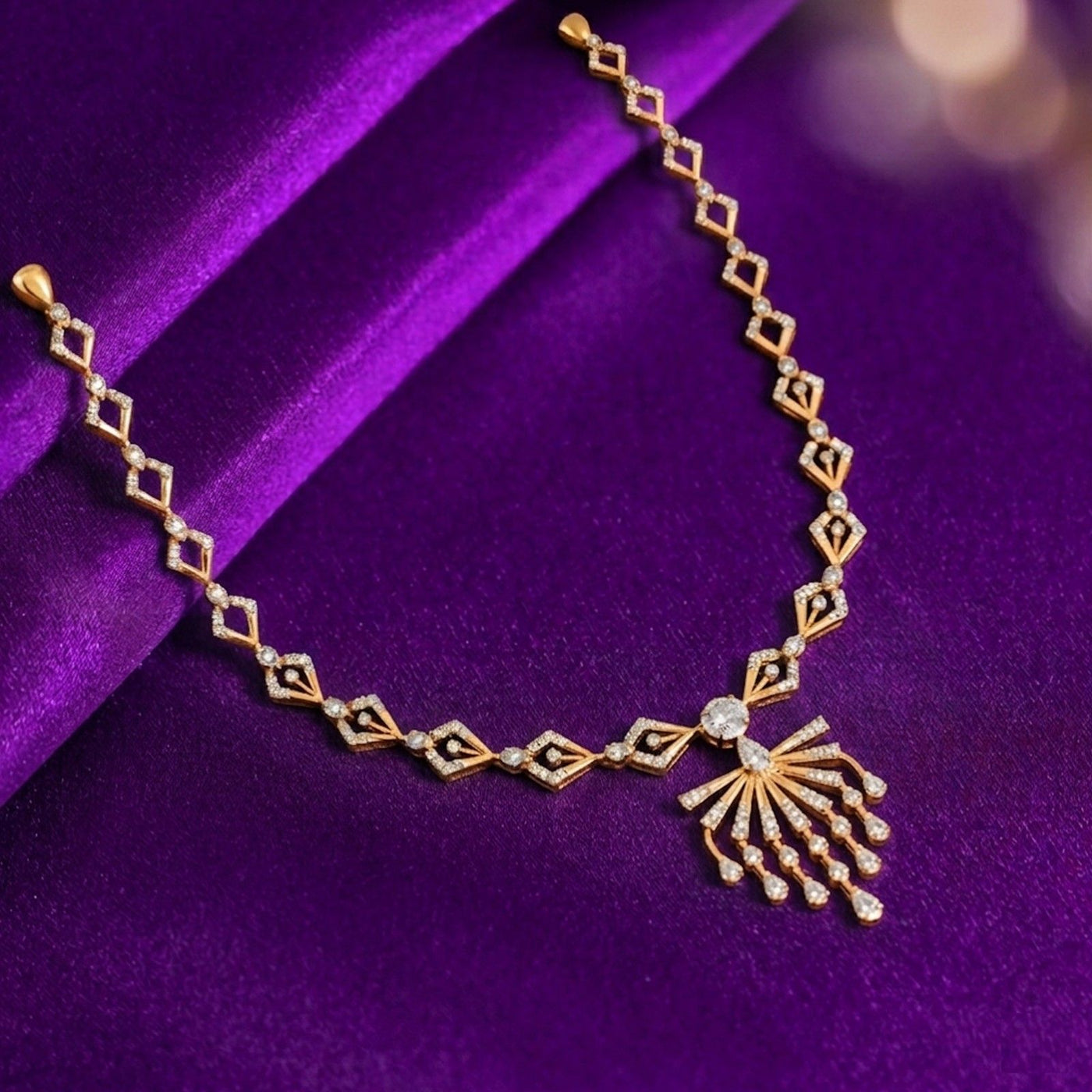 Gold necklace with diamond-like stones on a purple fabric background