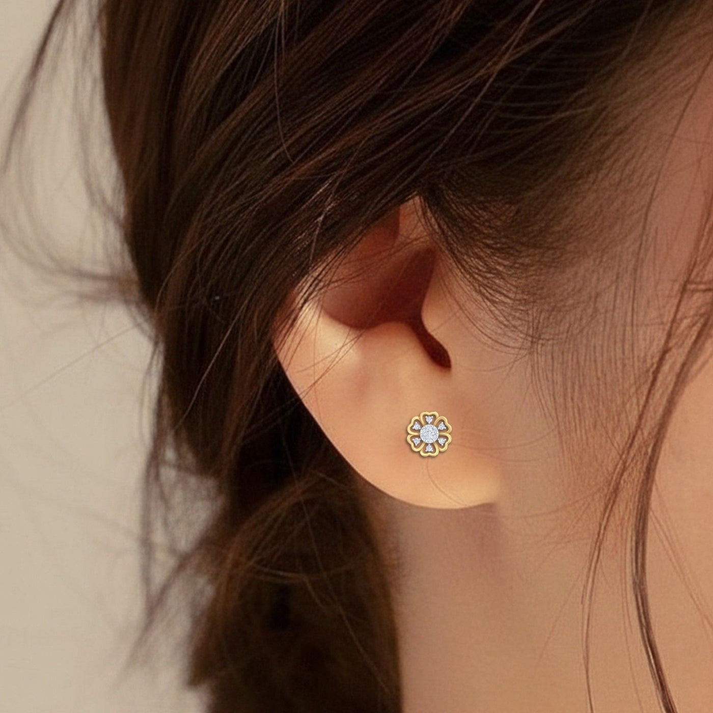 Close-up of a gold and diamond with floral-design stud earrings.
