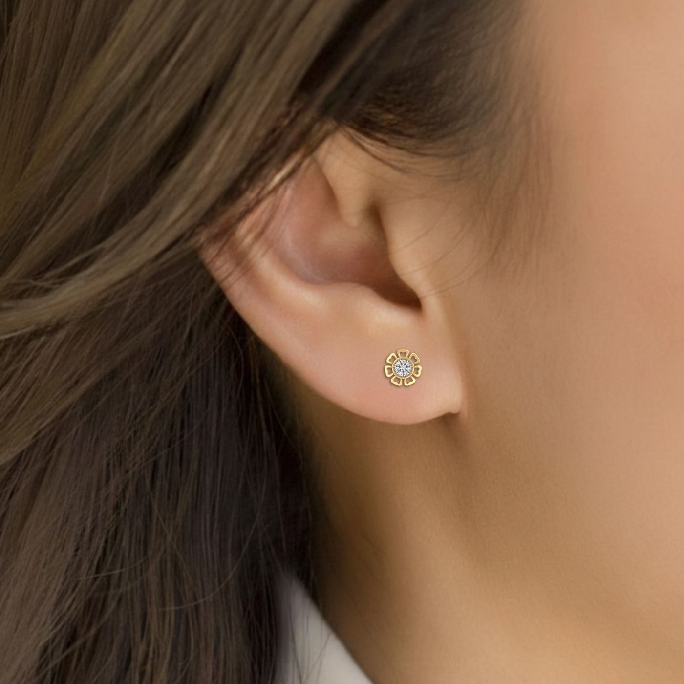 Close-up shot gold and diamond stud earring with floral-design.