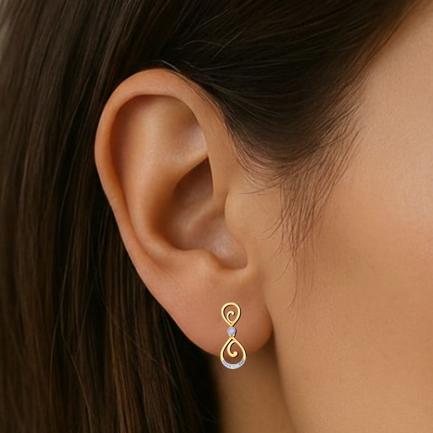 Close-up shot of a gold and diamond drop earring.