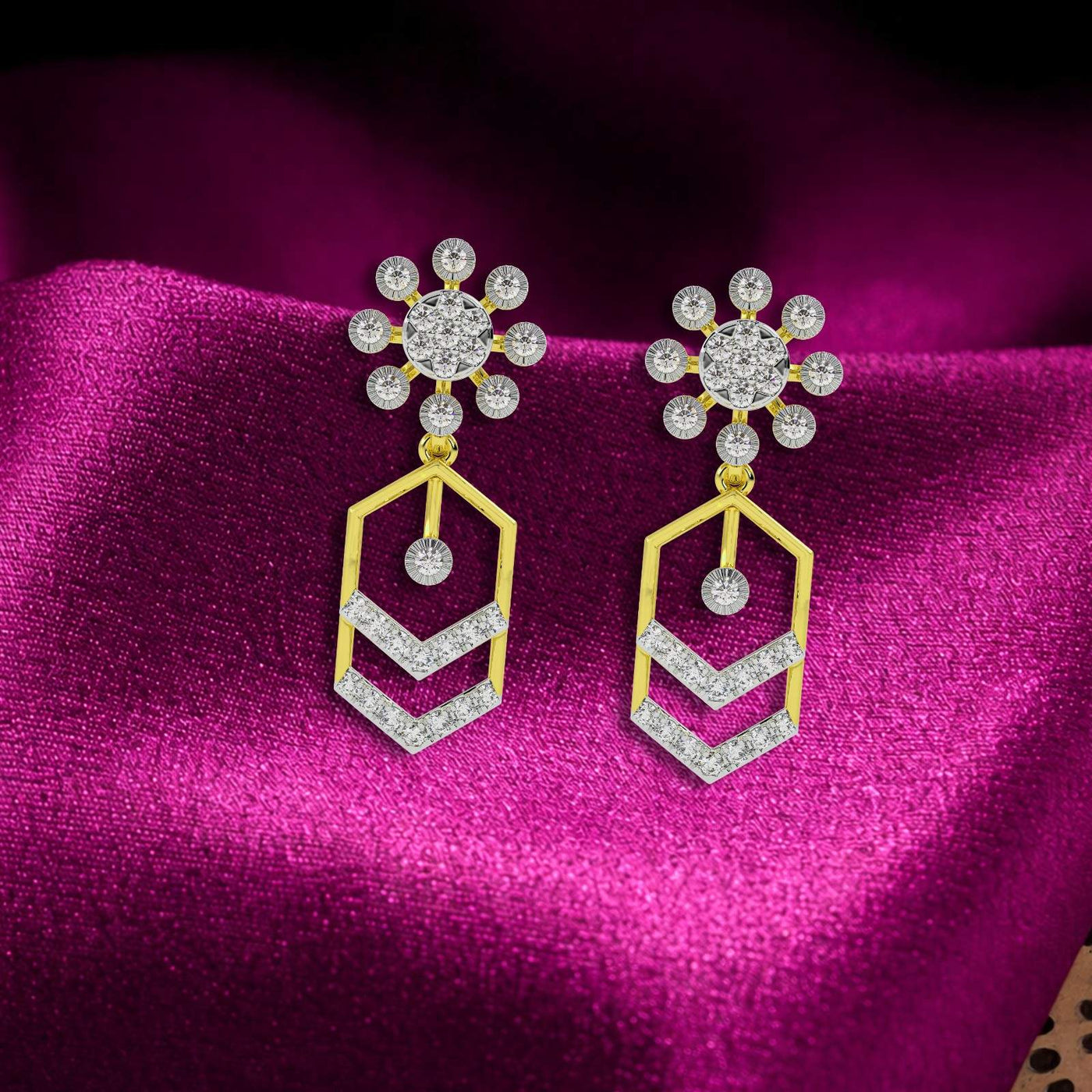 Pair of gold and diamond dangler earrings on a magenta background.