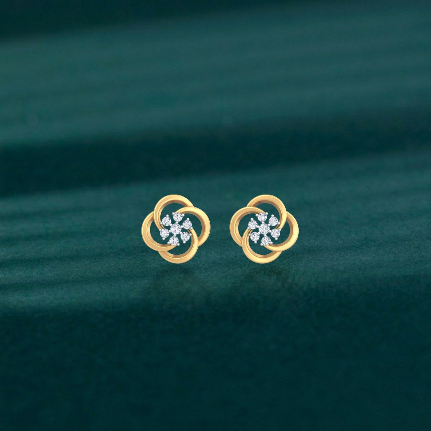 Gold and diamond stud earrings with floral-design on a teal background.