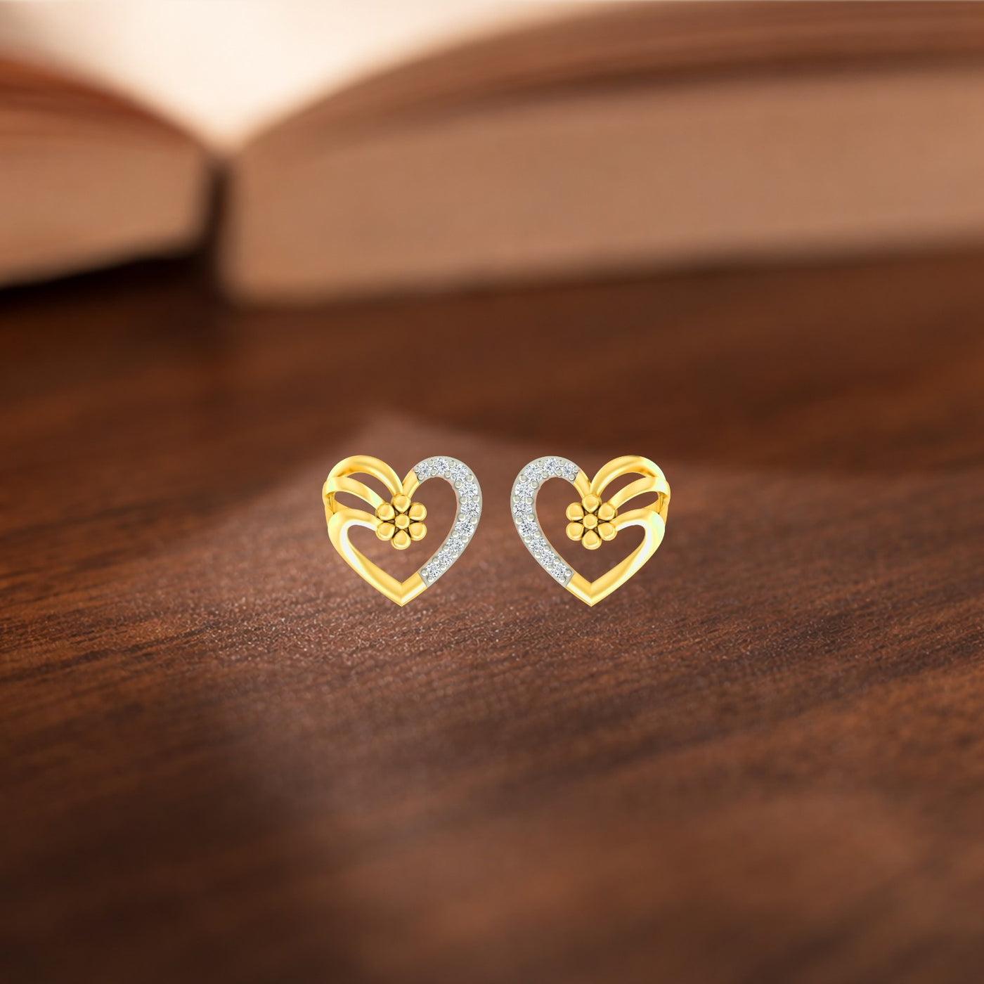 Yellow gold and diamond heart-shaped stud earrings on a wooden background
