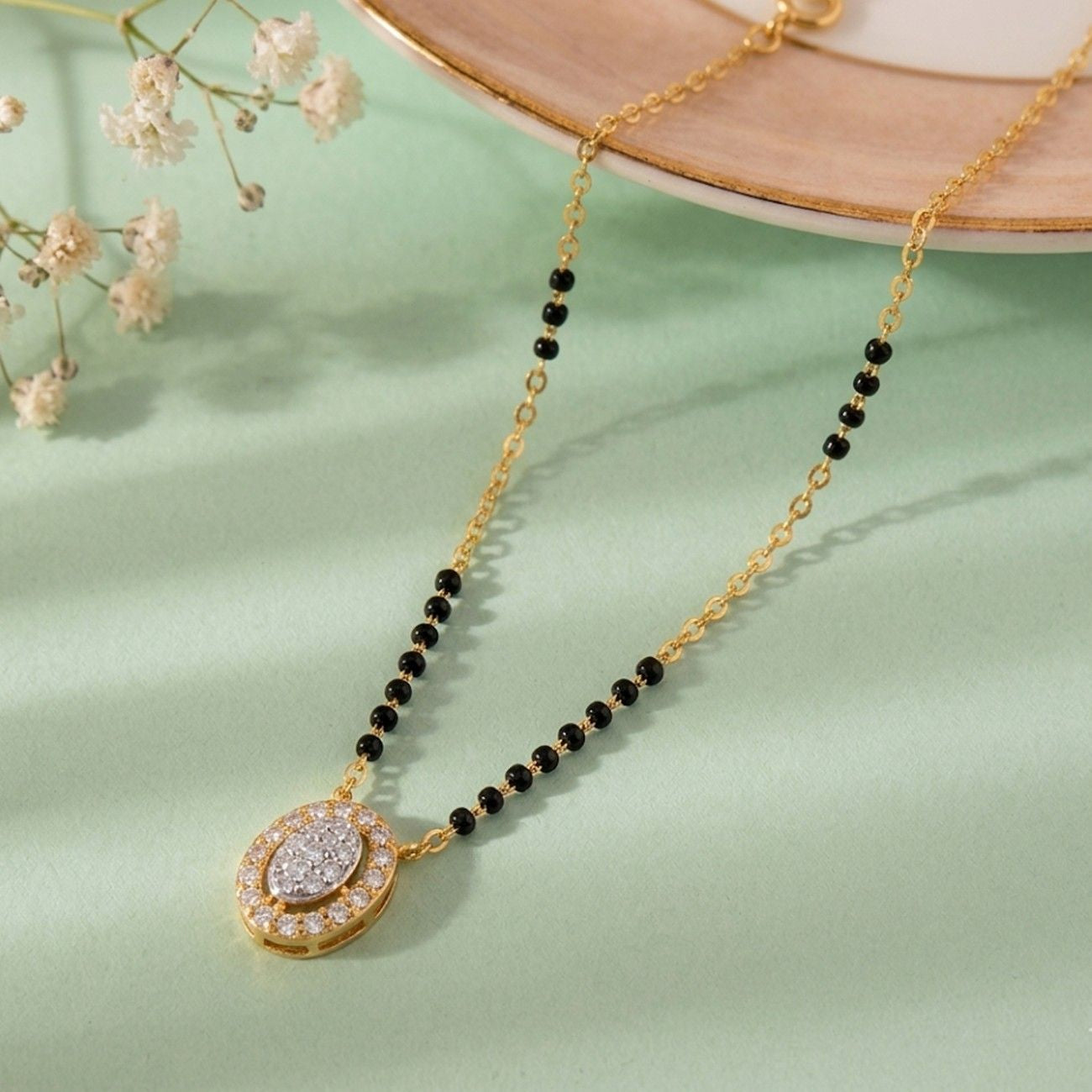 gold and diamond beaded mangalsutra on coloured background