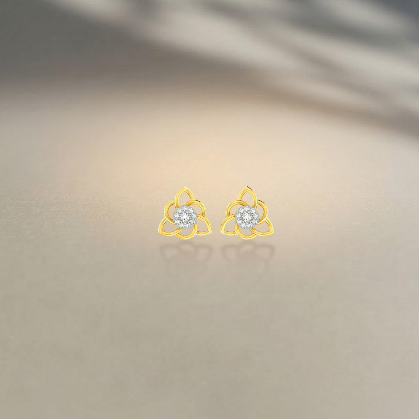 Gold and diamond stud earrings with floral  design on a beige background