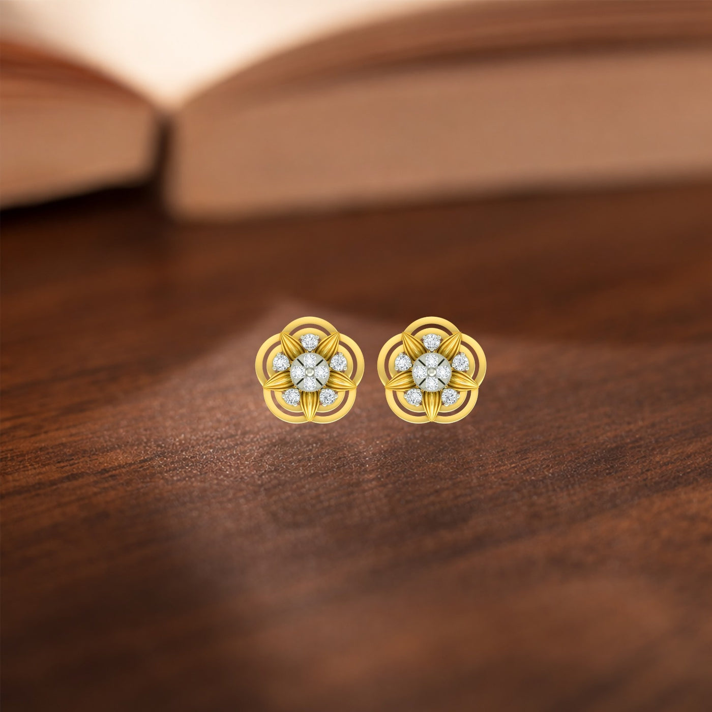 Gold and diamond flower-shaped earrings on a wooden surface.