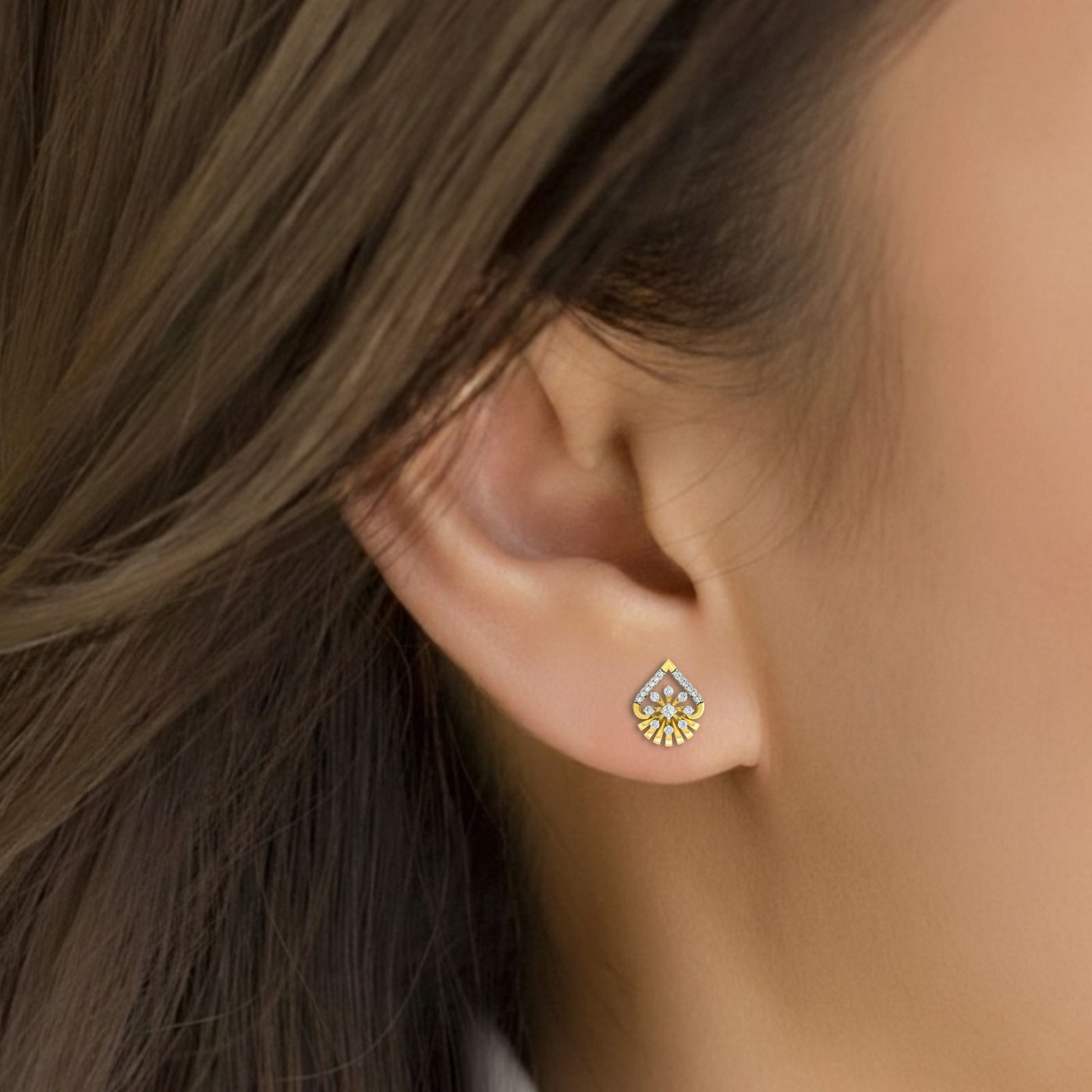 Close-up shot of a gold and diamond earrings with diamond accents earring.