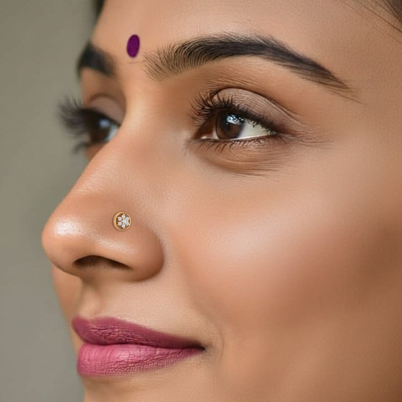 Close-up of a woman's face with a nose pin and pink lipstick.