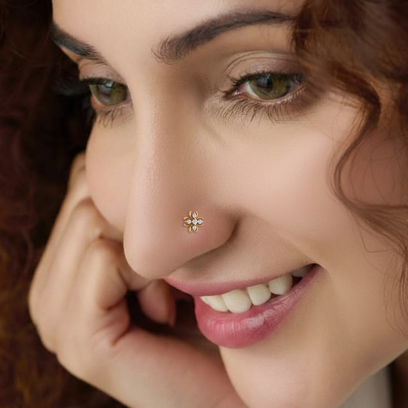 Close-up of a woman's face with a nose pin, smiling.