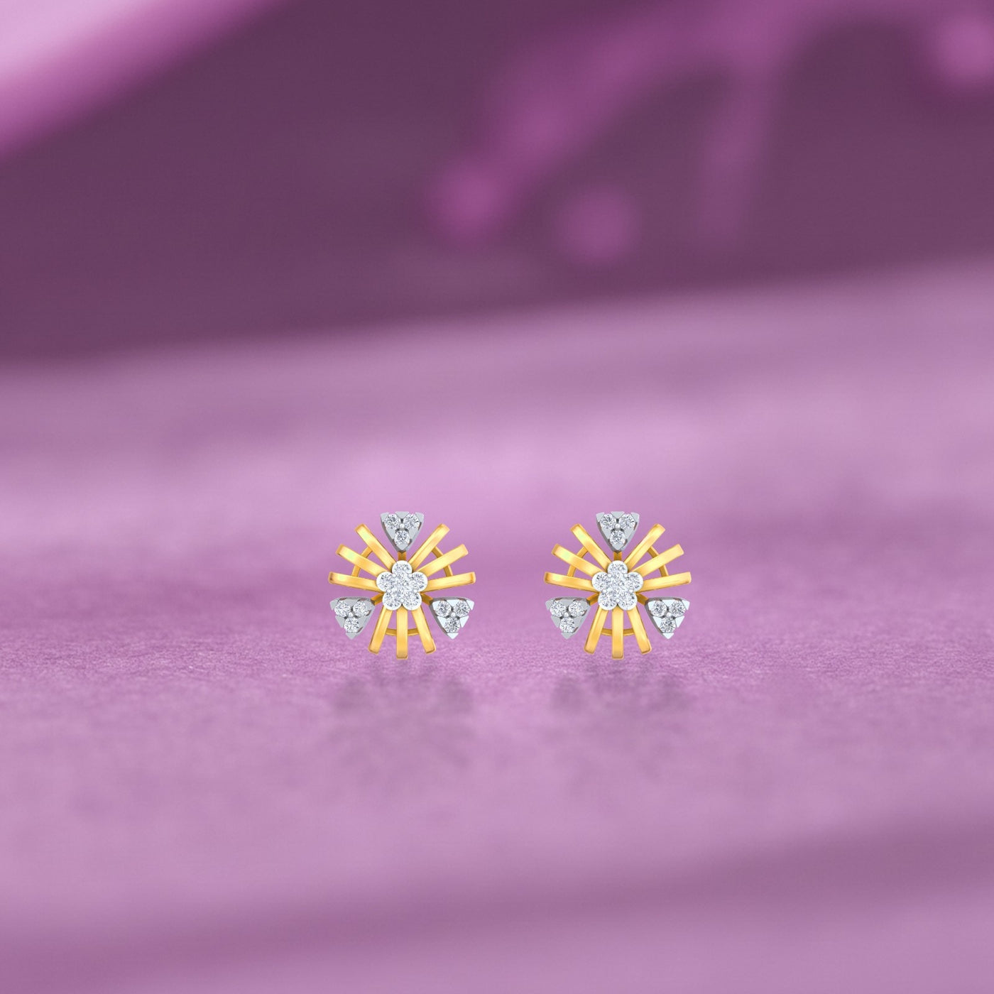 Gold and diamond round-shaped stud earrings on a purple surface. 