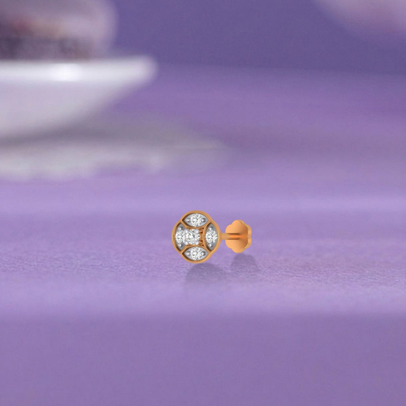 yellow old and diamond stud nose pin with gemstones on a purple surface