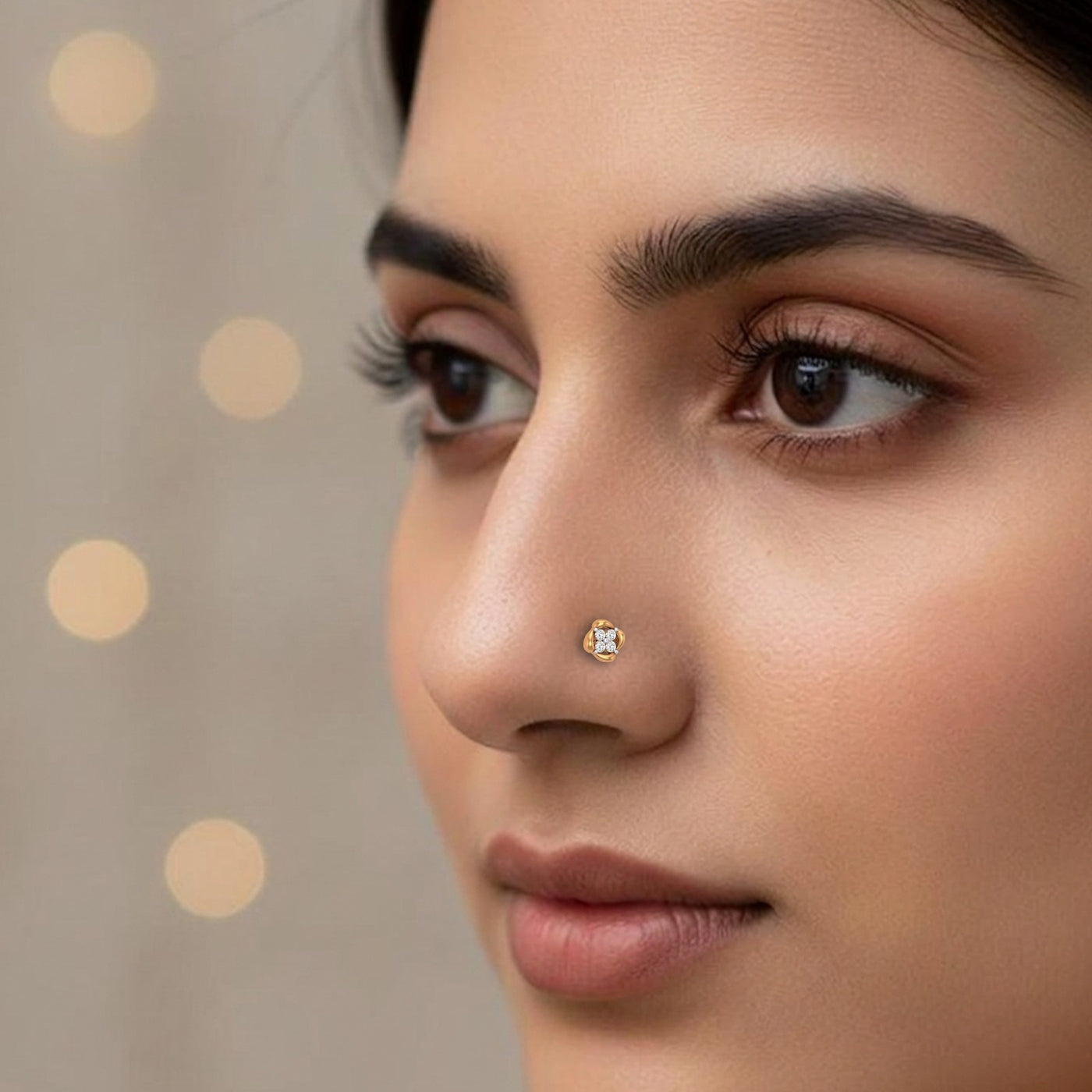 Close-up of a woman's face with a diamond nose pin against a neutral background