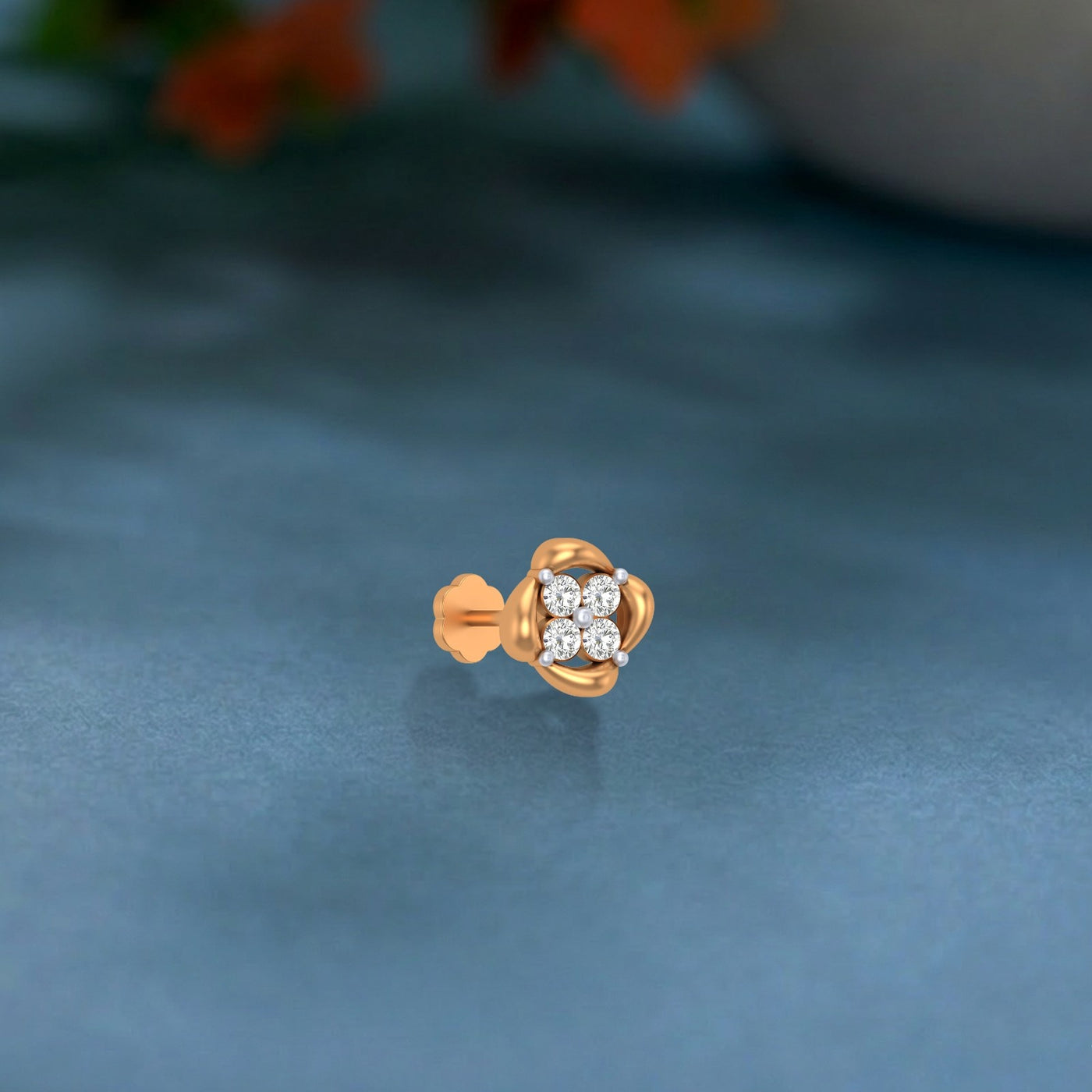 yellow gold and diamond stud nose pin on a blue background
