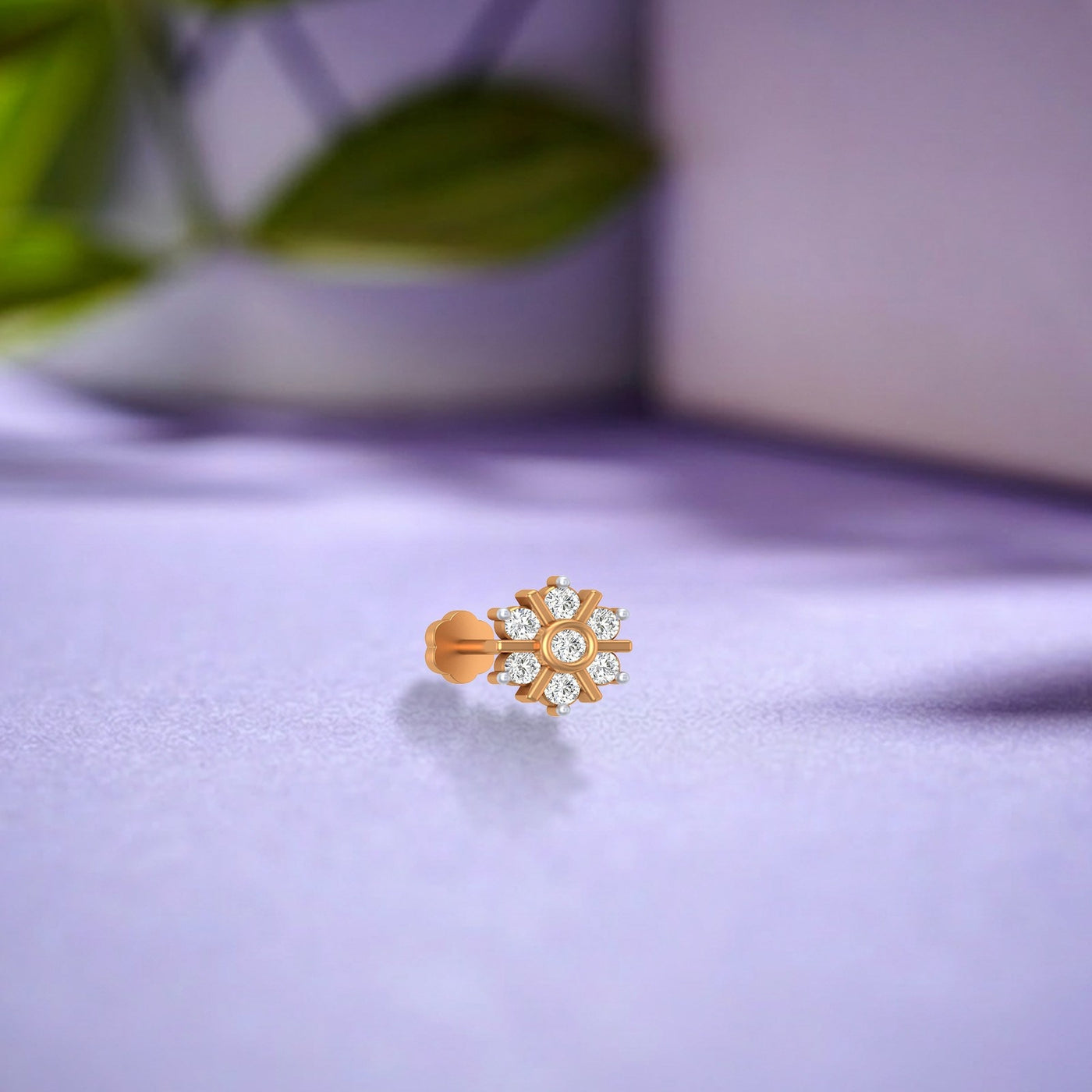 yellow gold and diamond stud nose pin with diamonds on a light purple surface