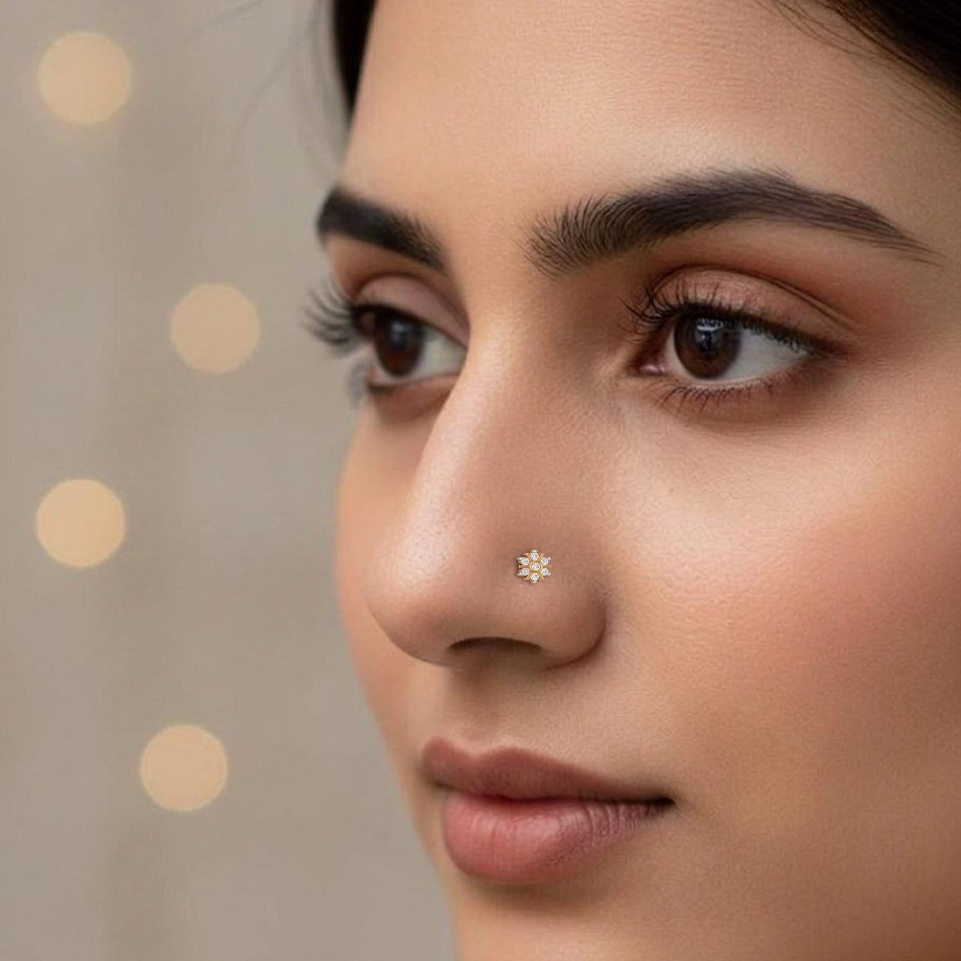 Close-up of a woman's face with a star-shaped nose pin against a neutral background