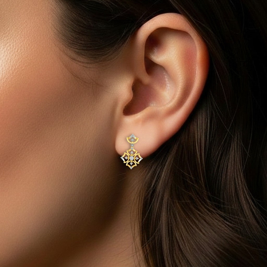 A close-up of a model's ear wearing a small gold geometric drop earring.