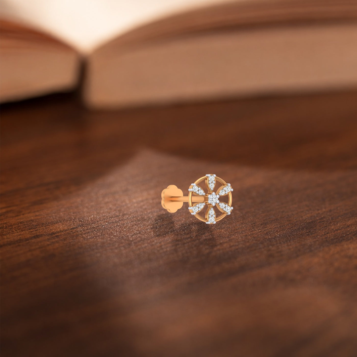 Yellow Gold and diamond stud nose pin-like stones on a wooden surface