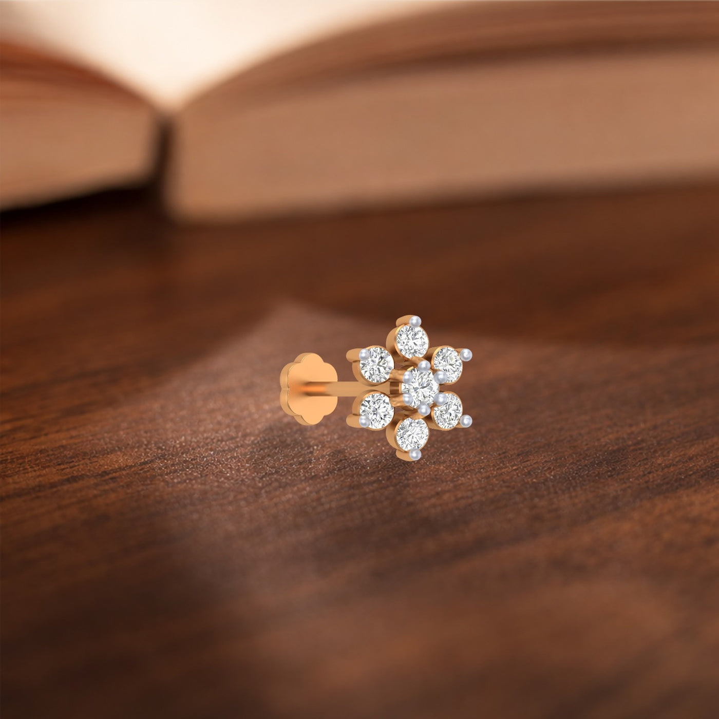 yellow gold and diamond stud nose pin on a wooden surface