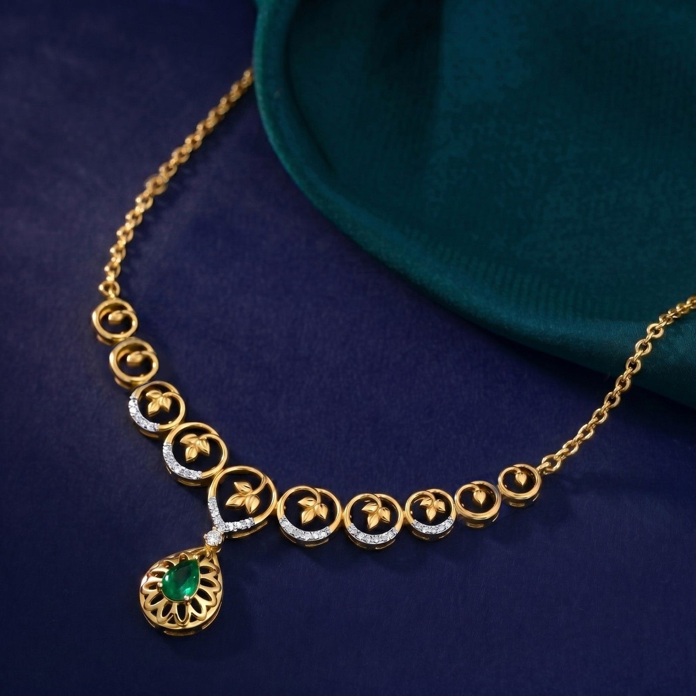 Gold necklace with a green gemstone pendant on a blue background