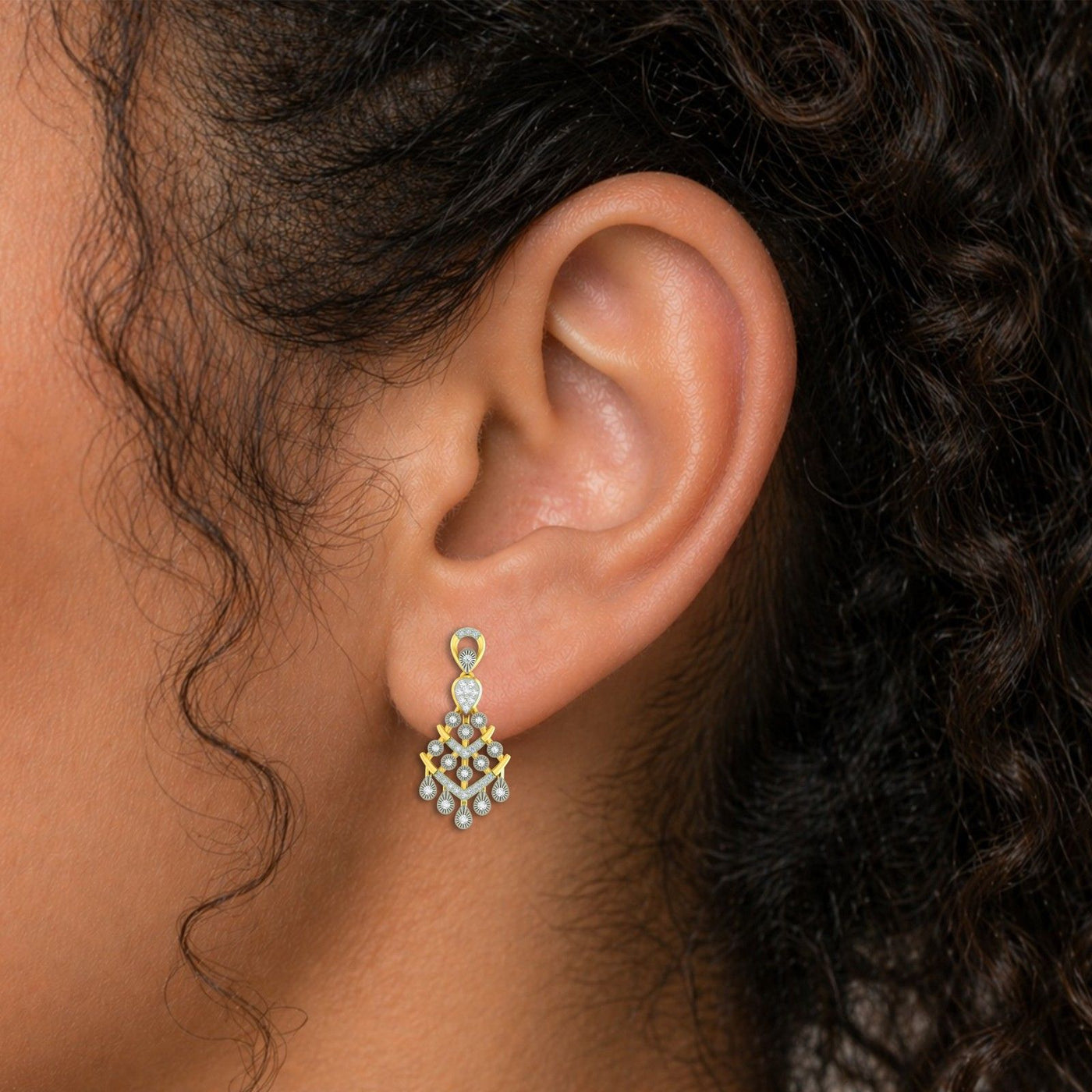 Close-up shot of gold and diamond chandelier earrings.