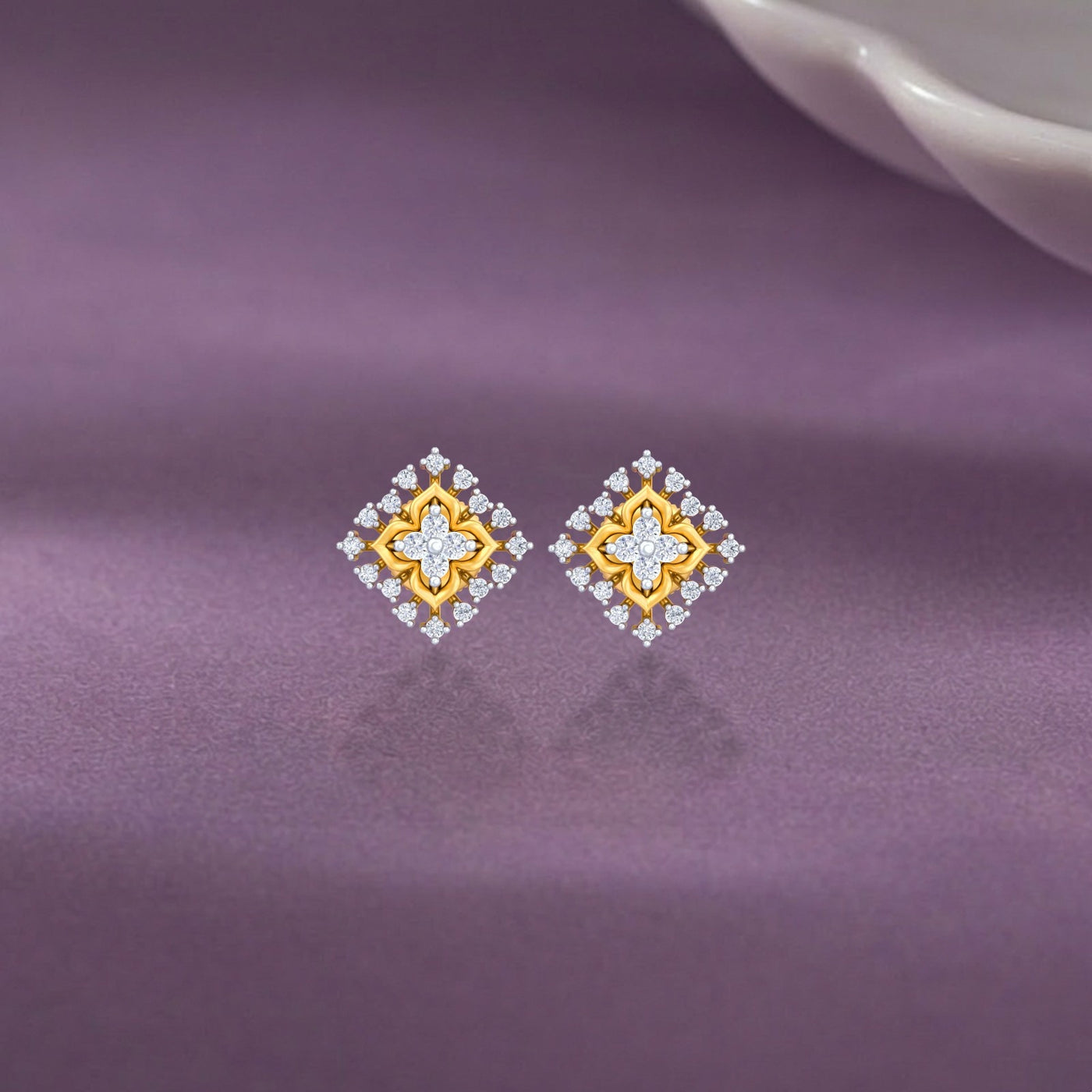 Gold and diamond stud earrings on a purple background.