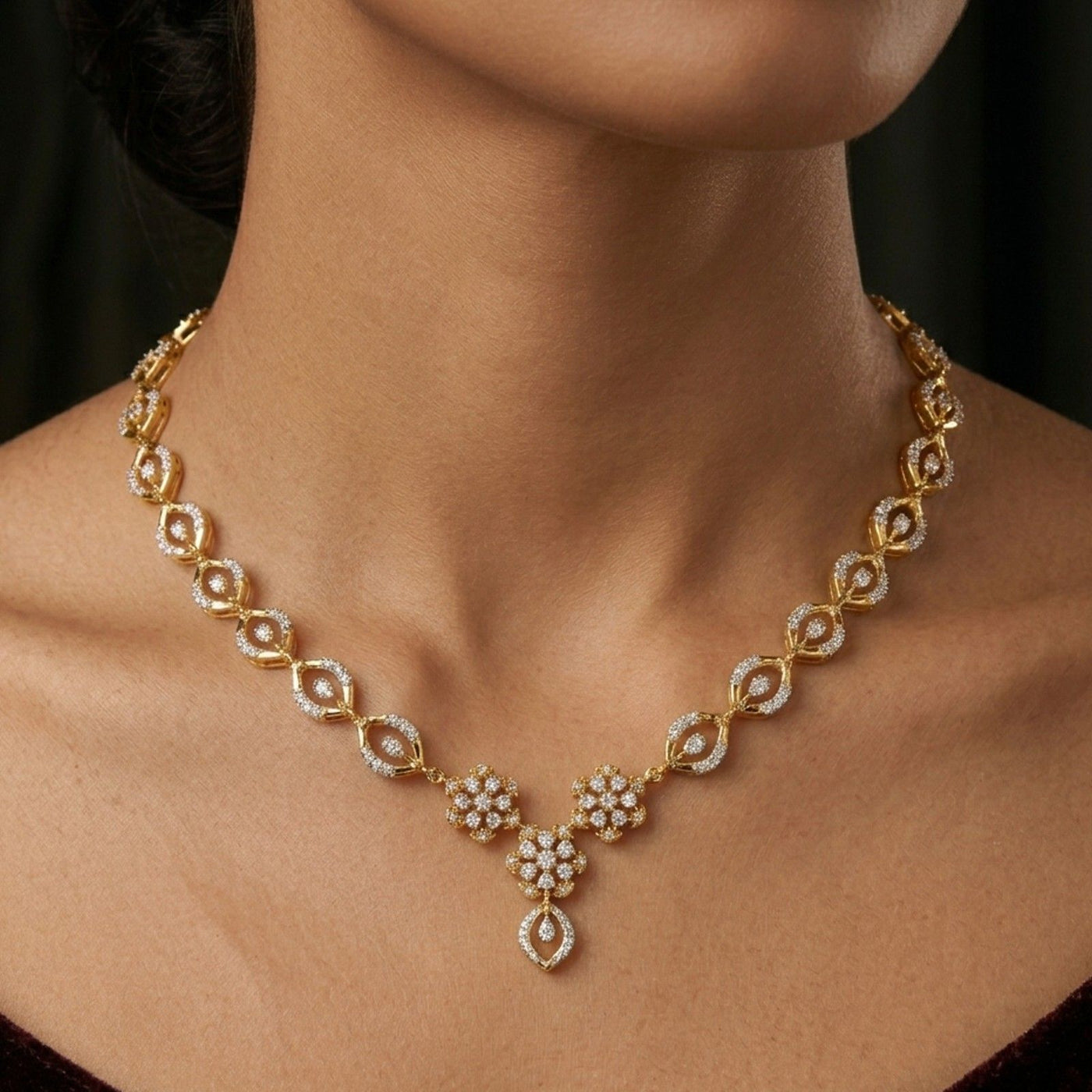 Gold necklace with diamond-like stones on a person's neck against a dark background