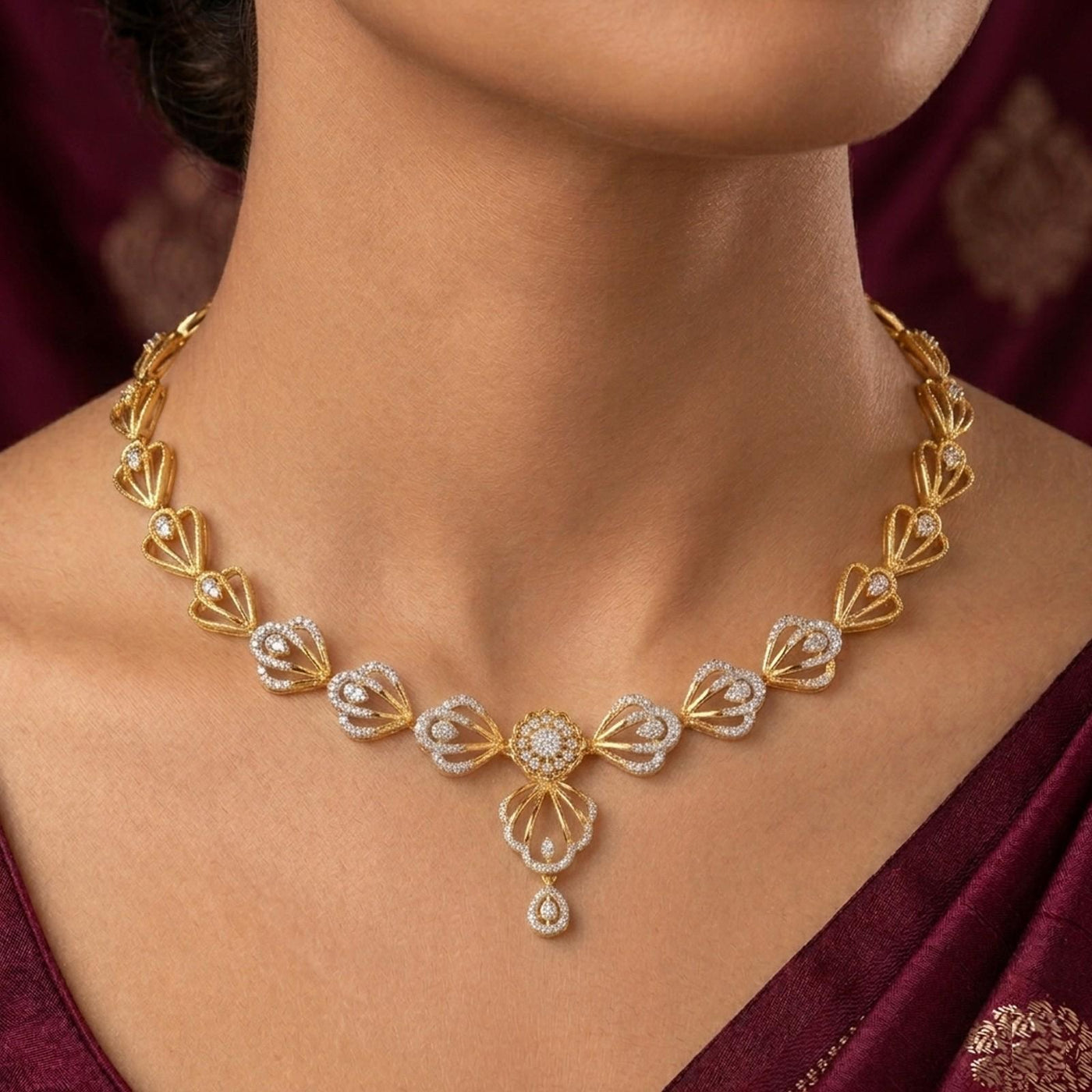 Gold necklace with diamonds on a person wearing a maroon saree.