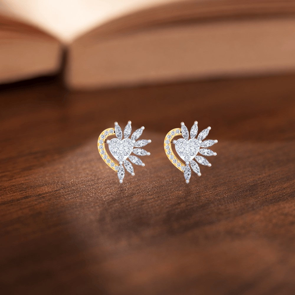 Pair of diamond earrings on a wooden surface with a blurred book in the background.