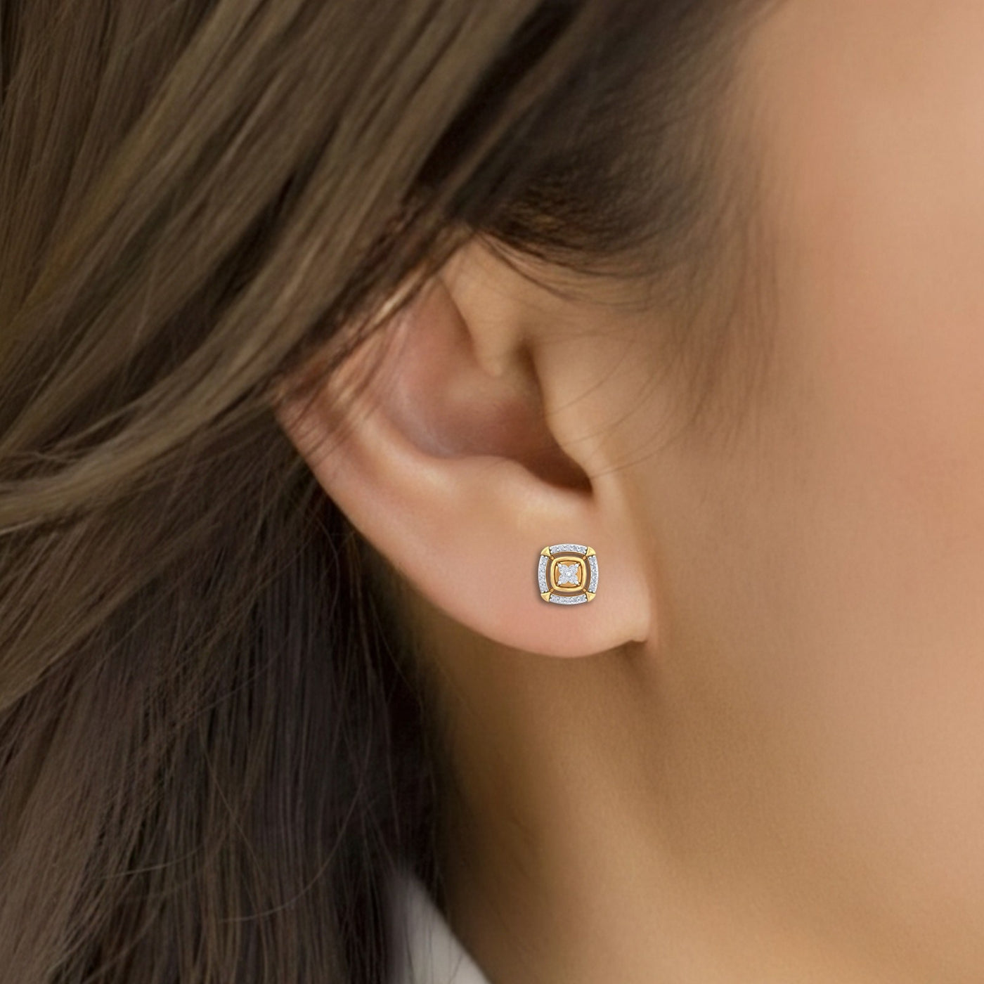 Close-up shot of a gold and diamond stud earring with Square-shaped design.