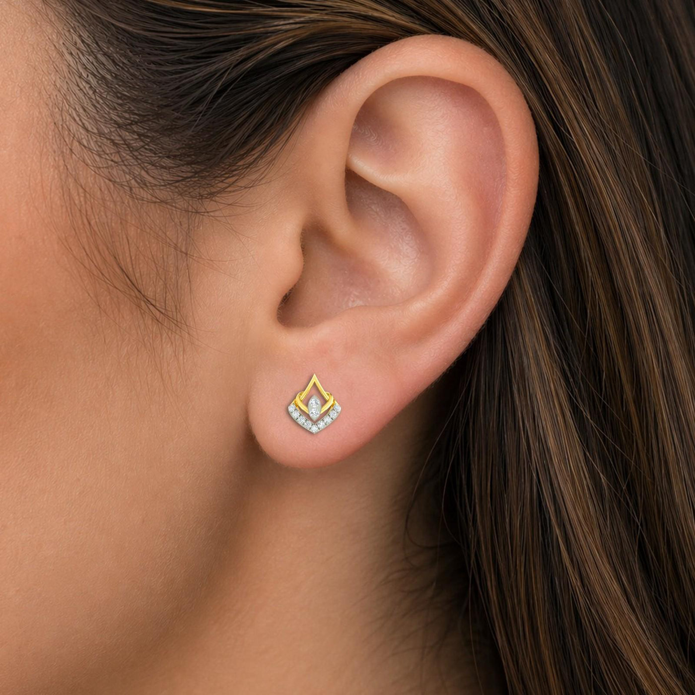 Close-up shot of a gold and diamond geometric stud earrings.