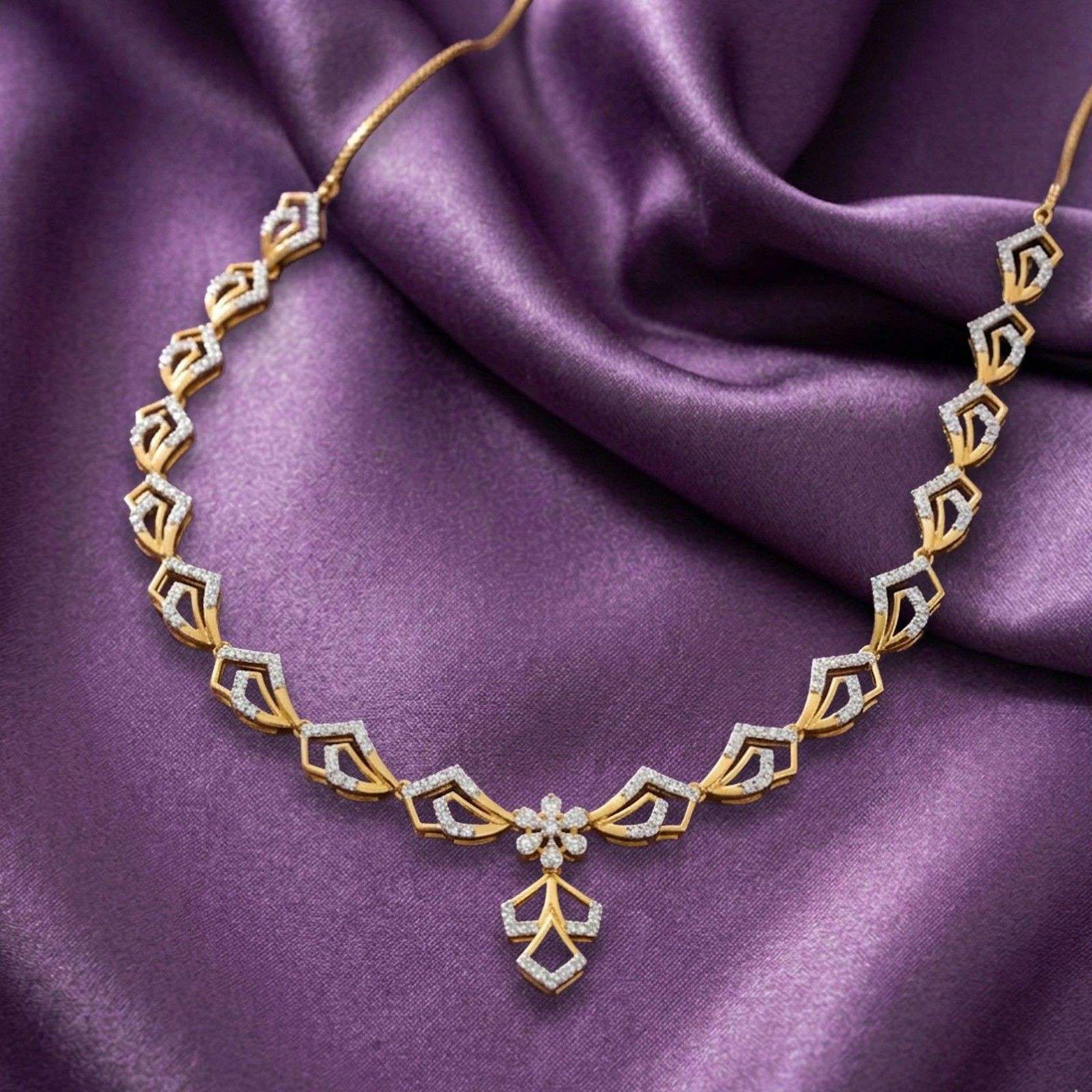 Gold and diamond necklace on a purple satin background