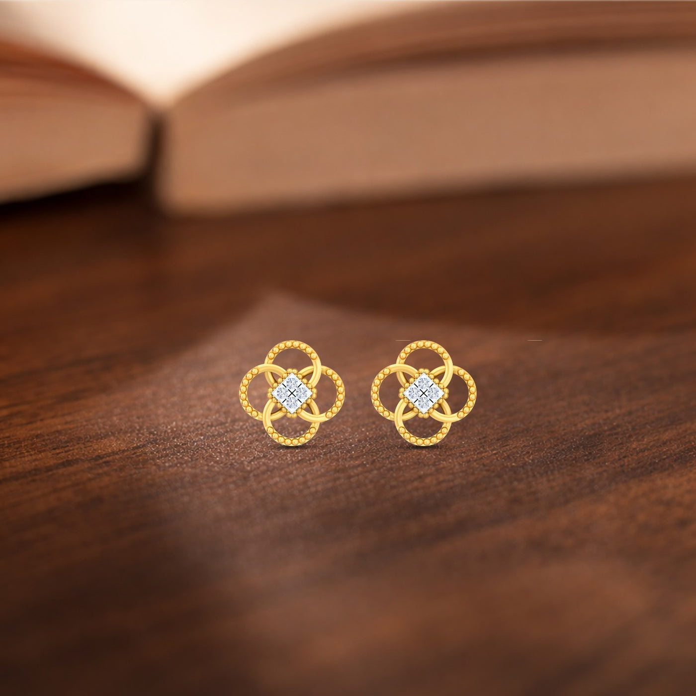 Gold and diamond floral stud earrings  on a wooden surface
