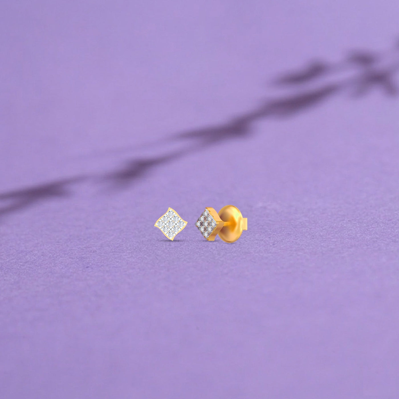 Gold and diamond dailywear stud earrings on a purple background.