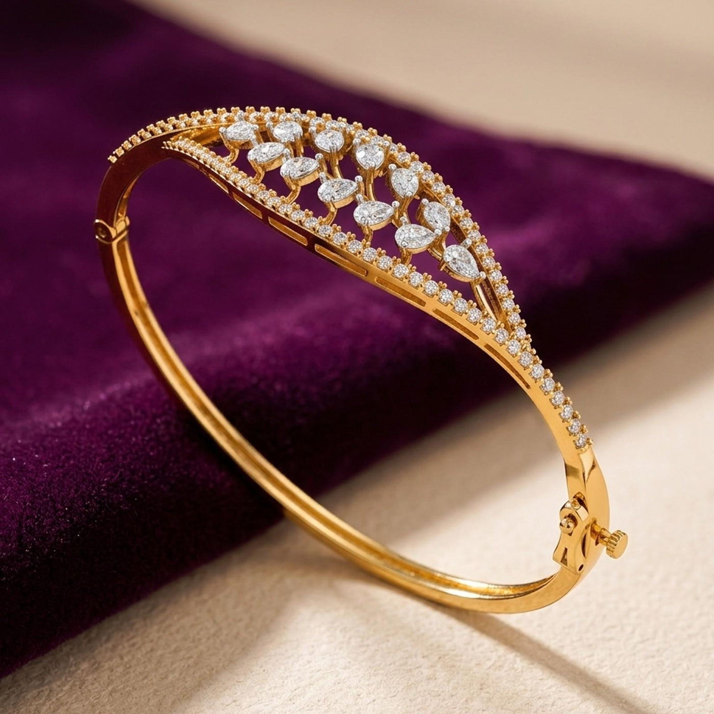 gold bangle bracelet with marquise diamond open-lattice design and pavé border.