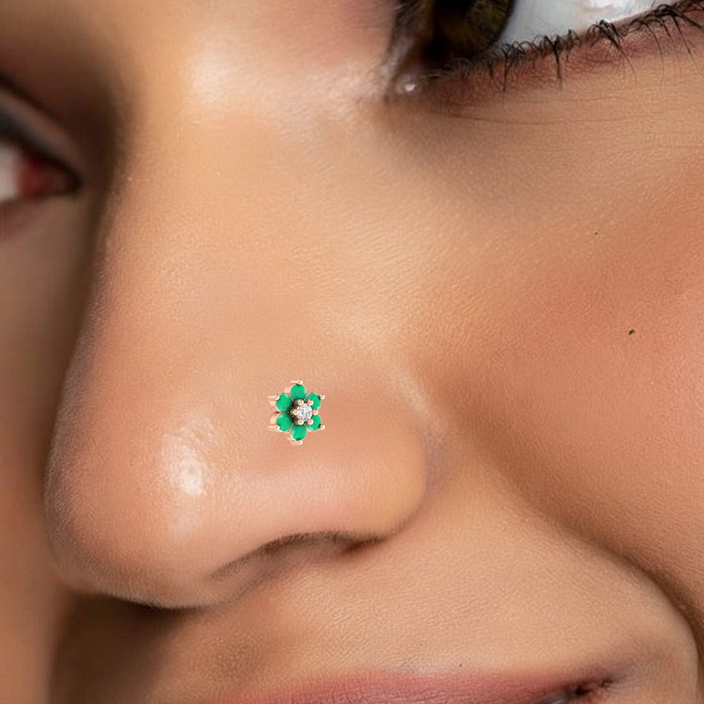 Close-up of a person wearing a green floral nose pin.