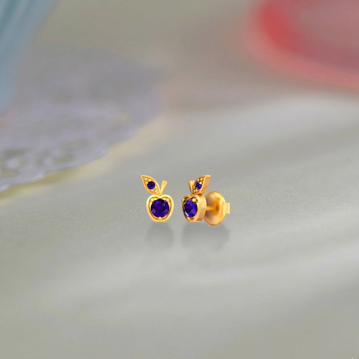 Gold and diamond stud earrings with shapphire gemstones on a background