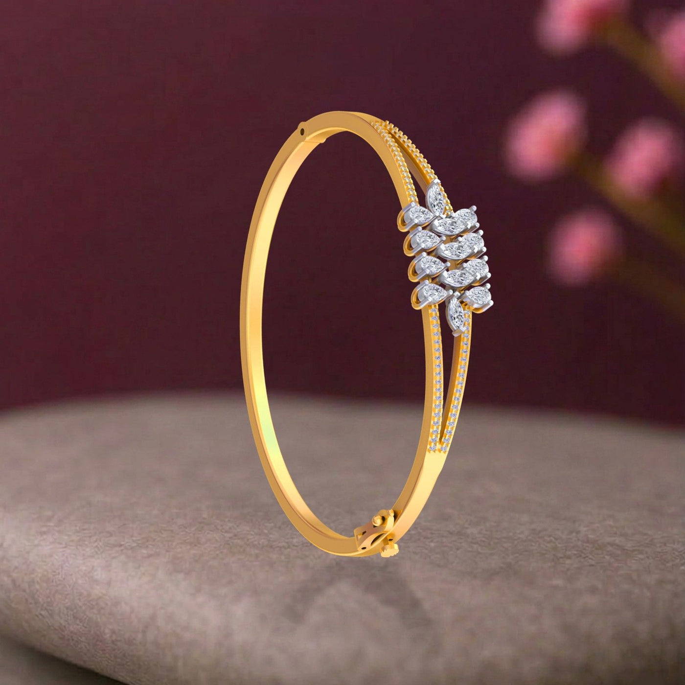 Yellow gold bangle bracelet with marquise and round diamond cluster centerpiece in leaf motif, featuring beaded edge band and safety clasp.