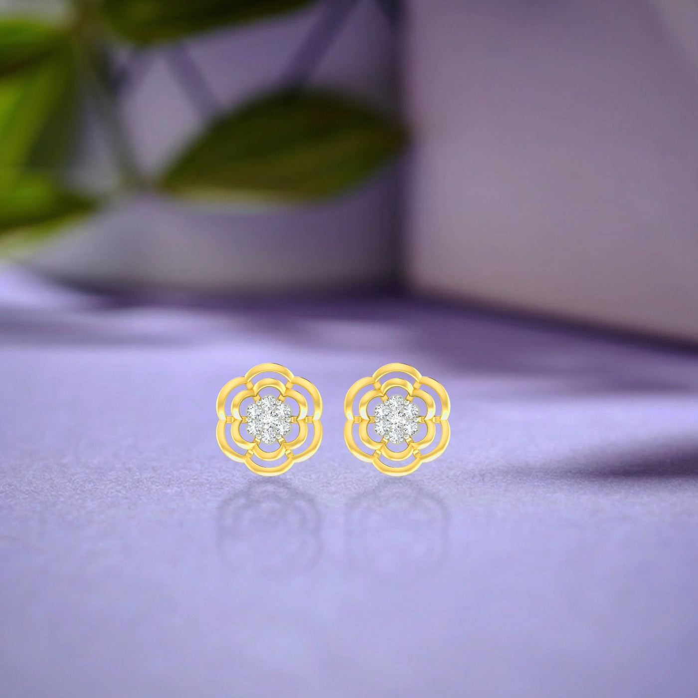 Gold and diamond stud earring with floral-design on a blue background.