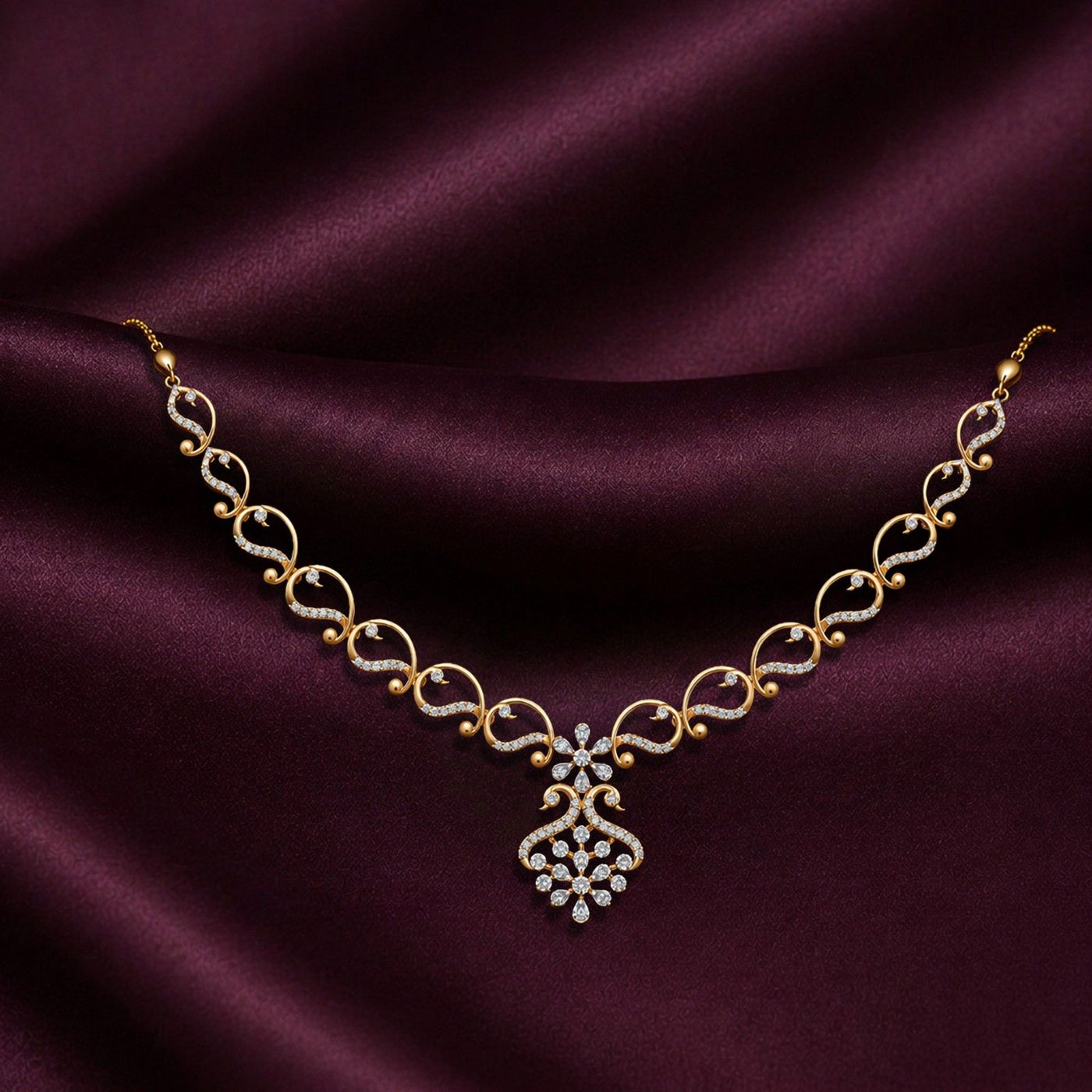 Gold necklace with a center floral on a purple fabric background