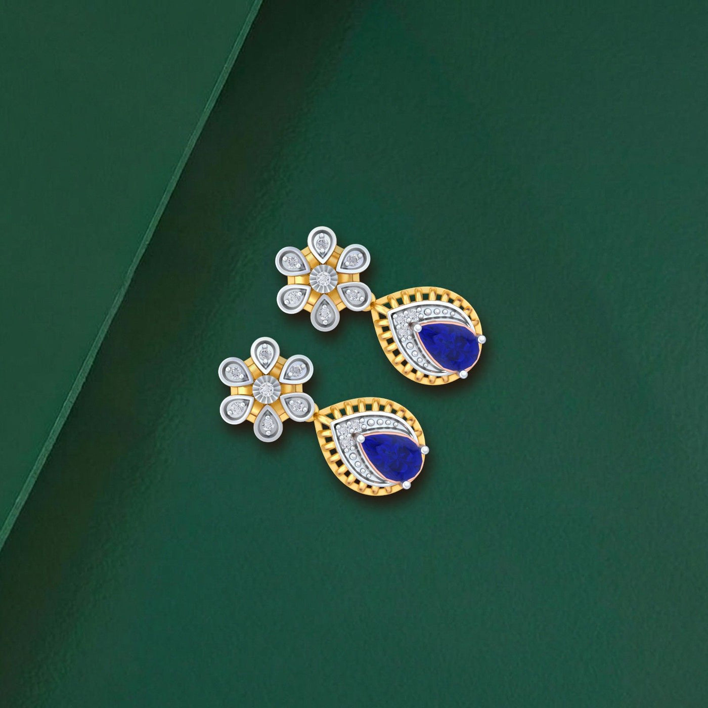 Gold and diamond gemstone earrings on a green background