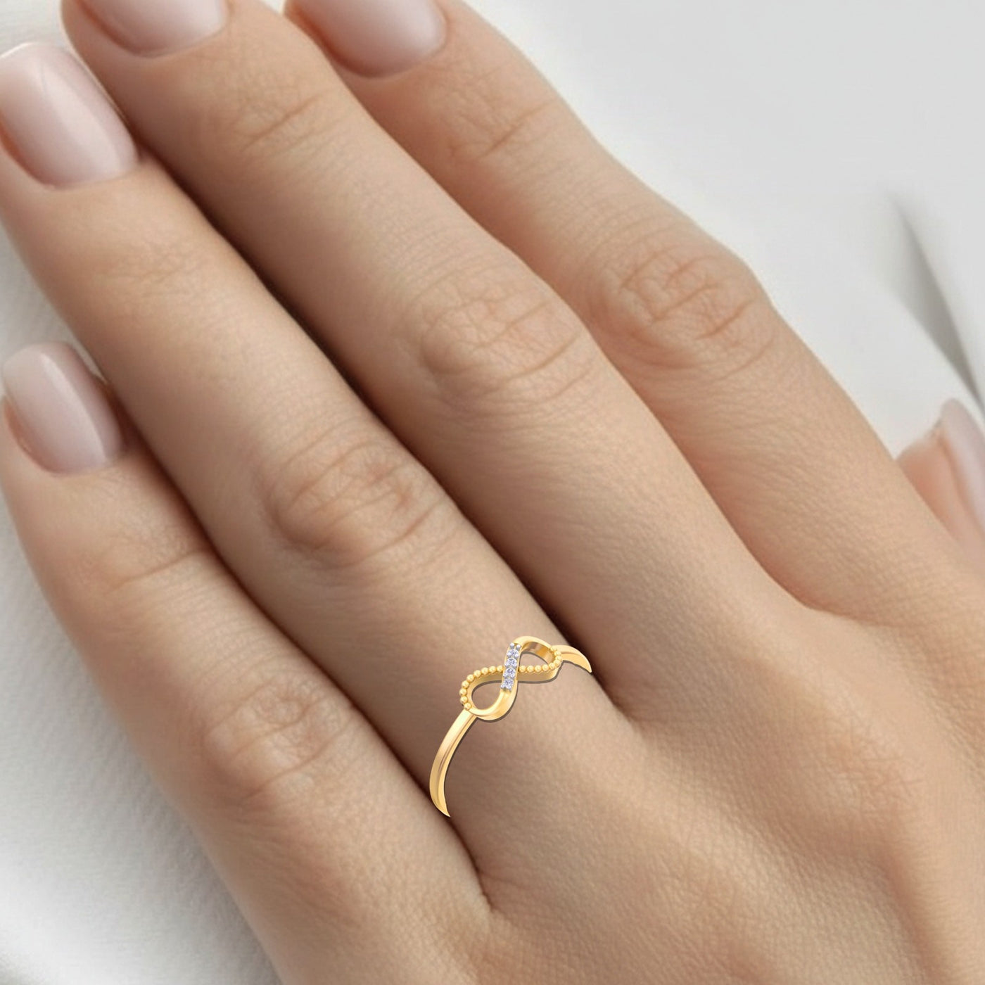 Gold ring with a diamond on a hand against a white background