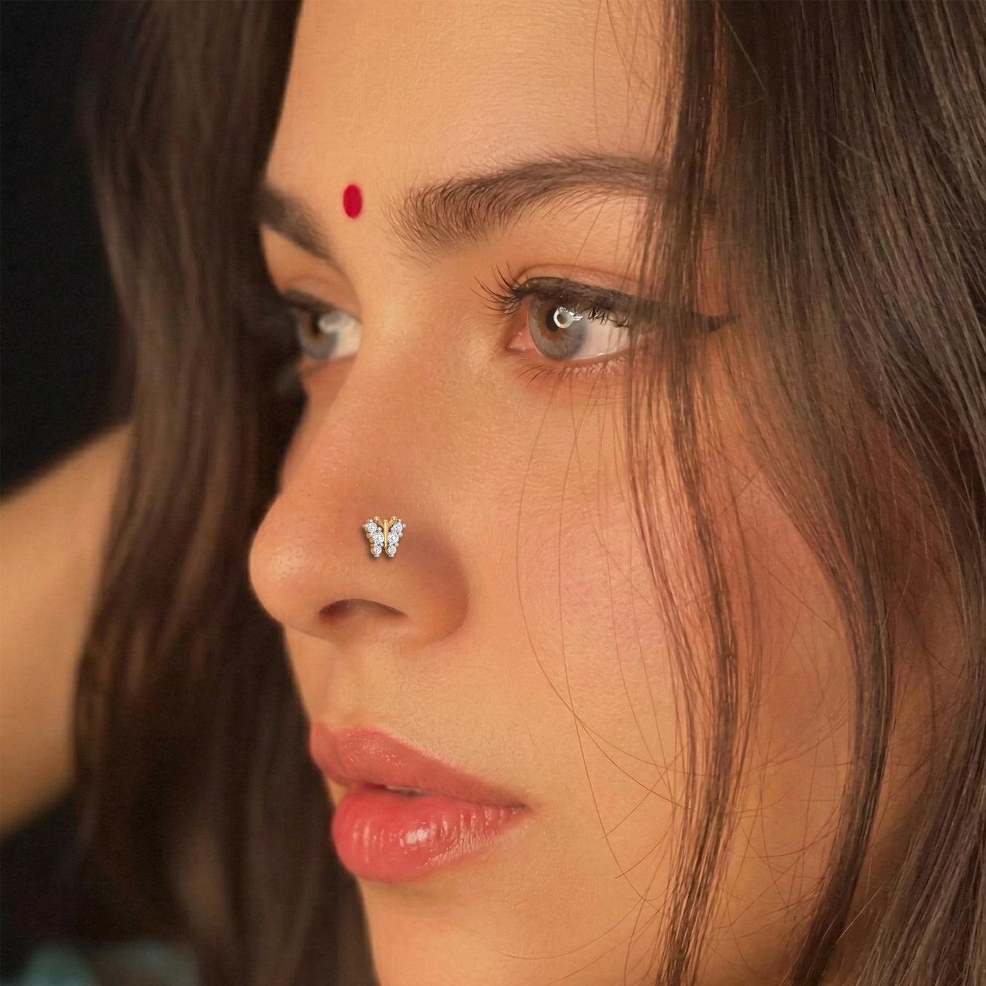 Close-up of a woman's face with butterfly nose pin