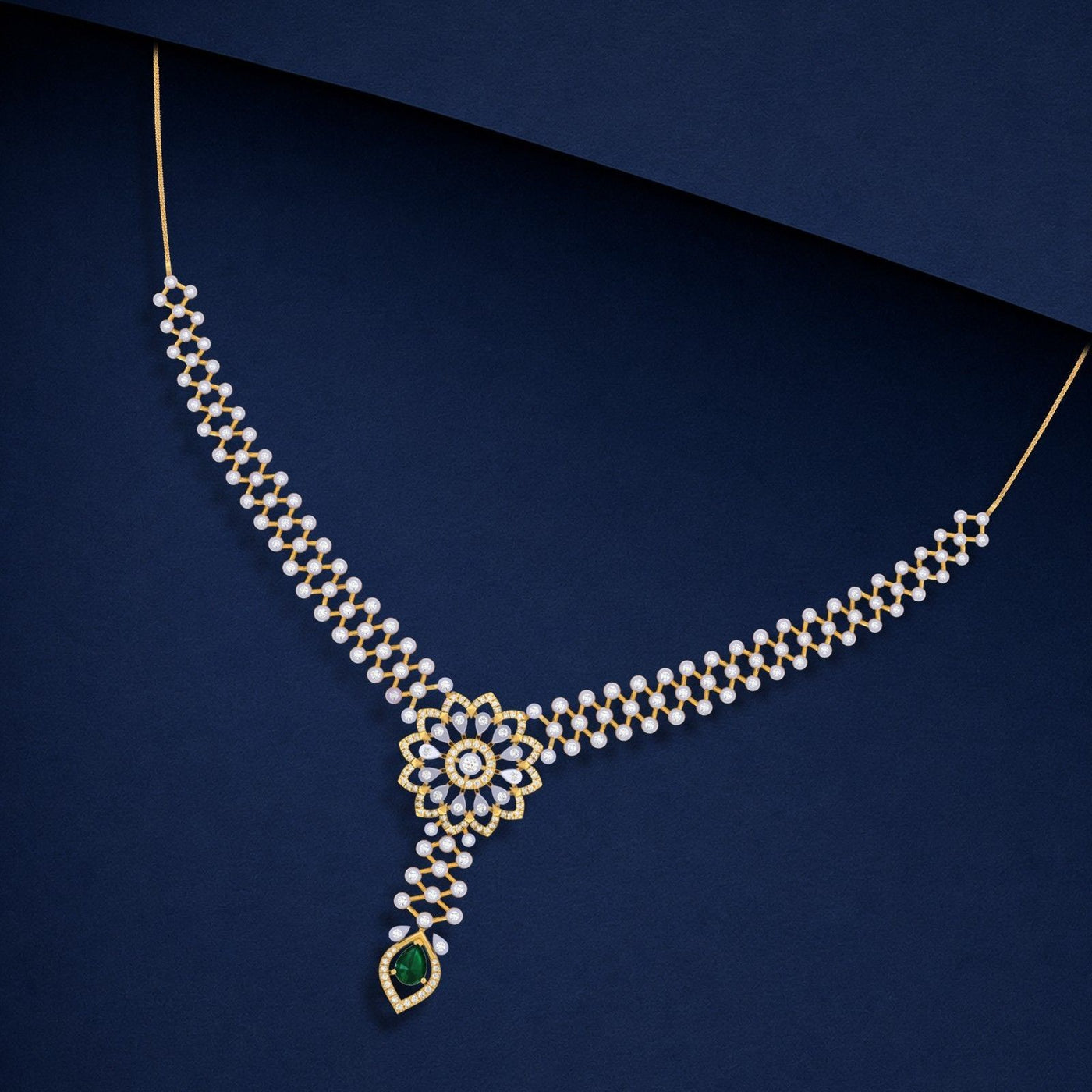 Gold and diamond necklace featuring a Y-shaped design with a central floral cluster of clear stones and a teardrop-shaped green gemstone.