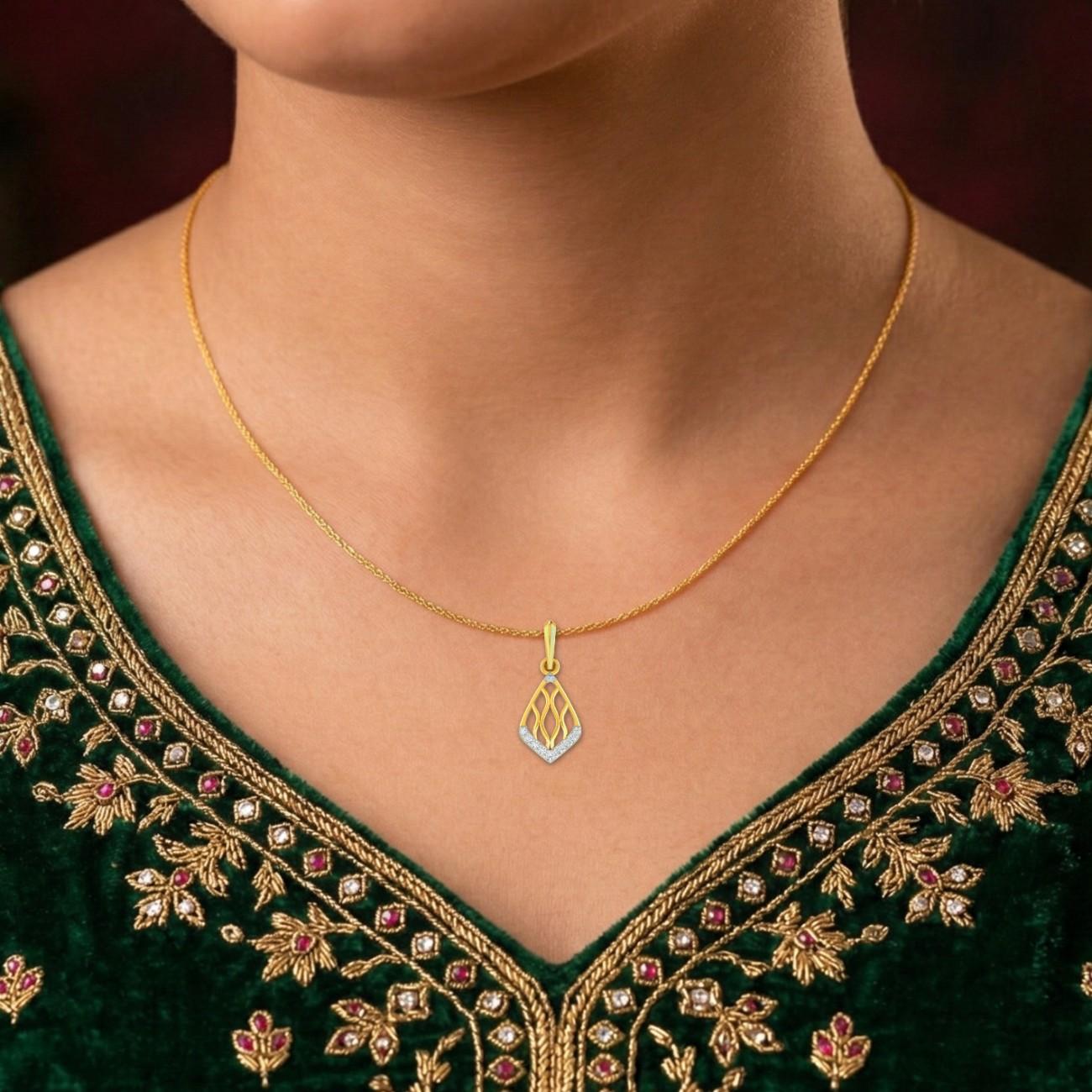 Gold necklace with a pendant on a person wearing a green embroidered garment.