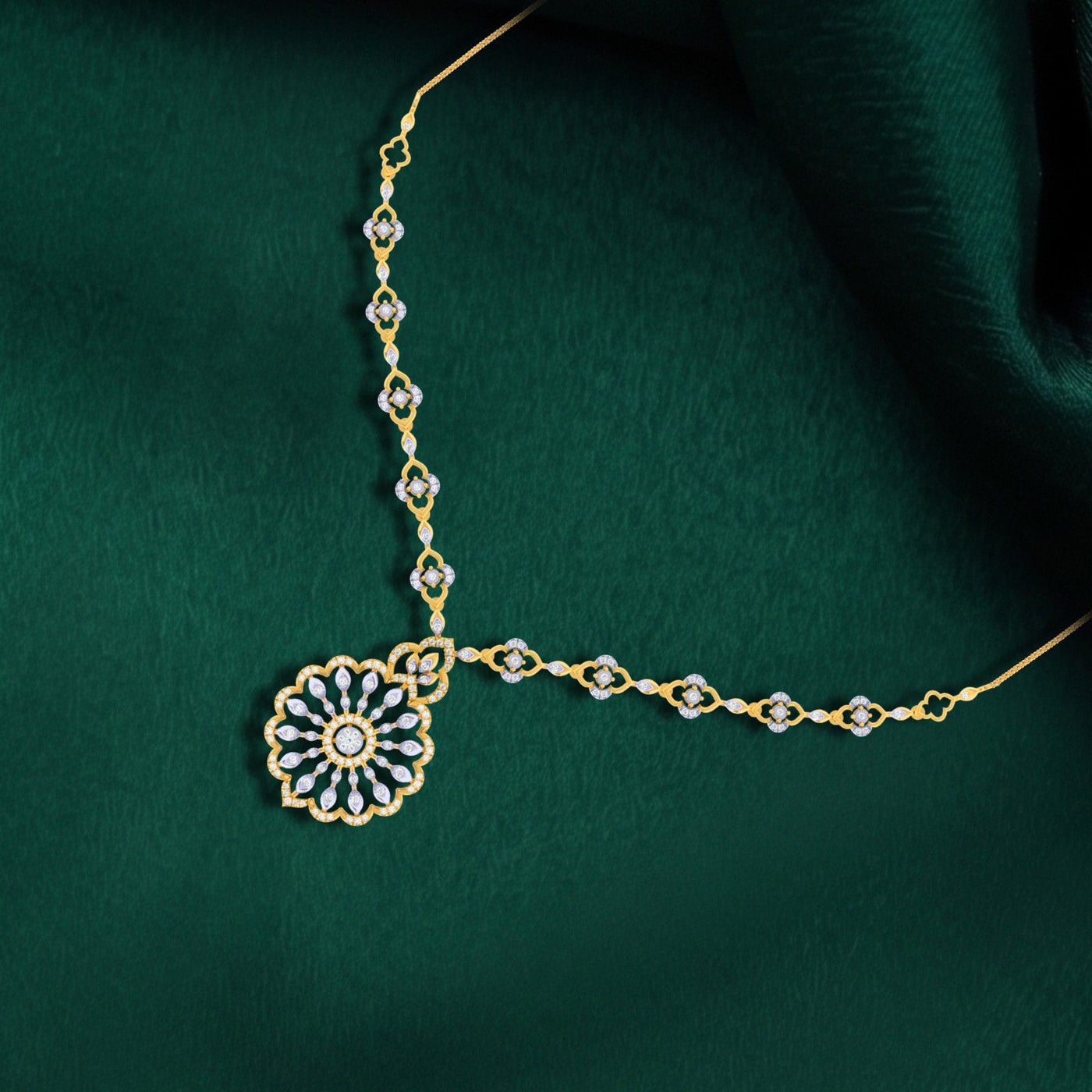 Decorative gold necklace with a floral design on a green fabric background