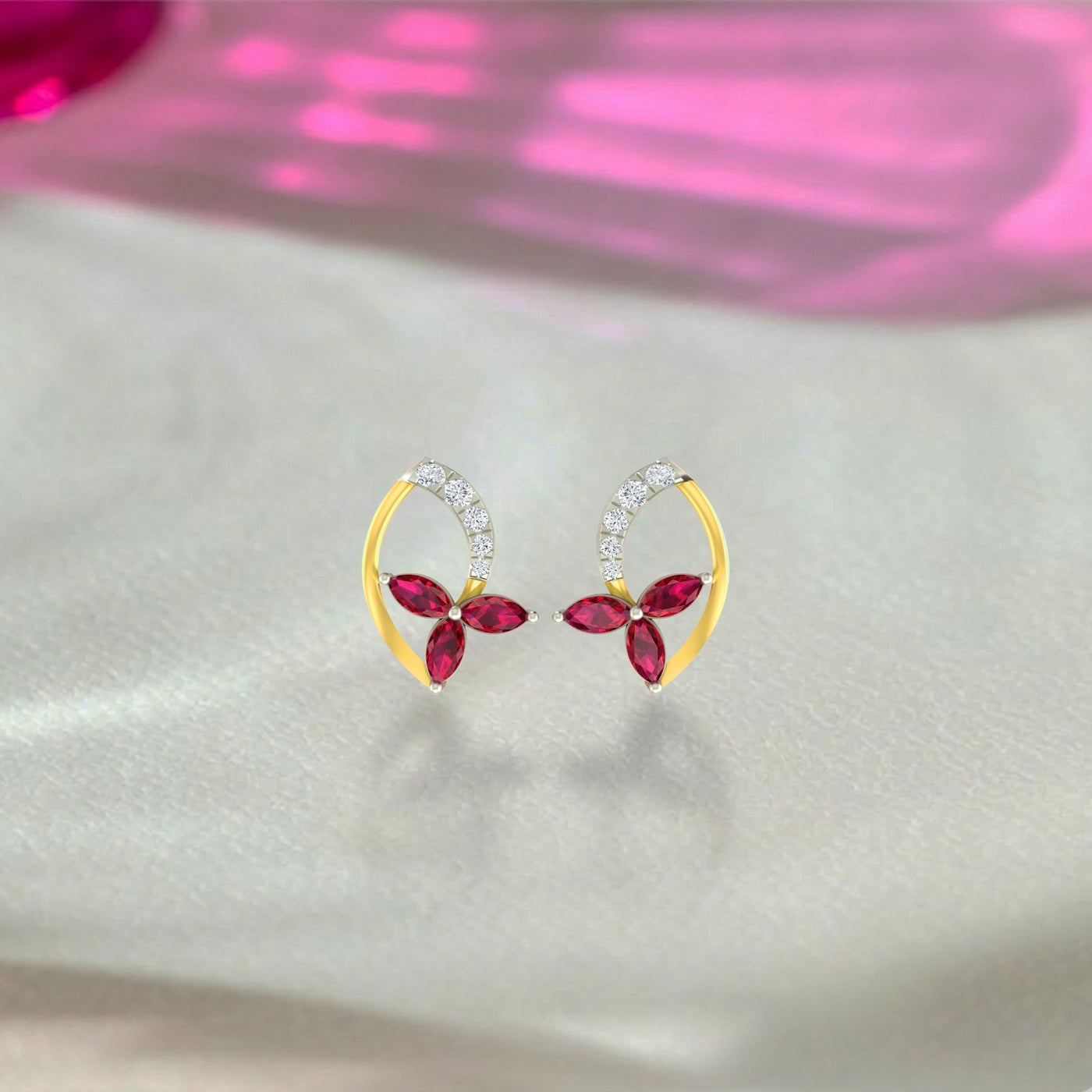 Yellow gold and diamond stud earring with ruby gemstone on a grey surface.