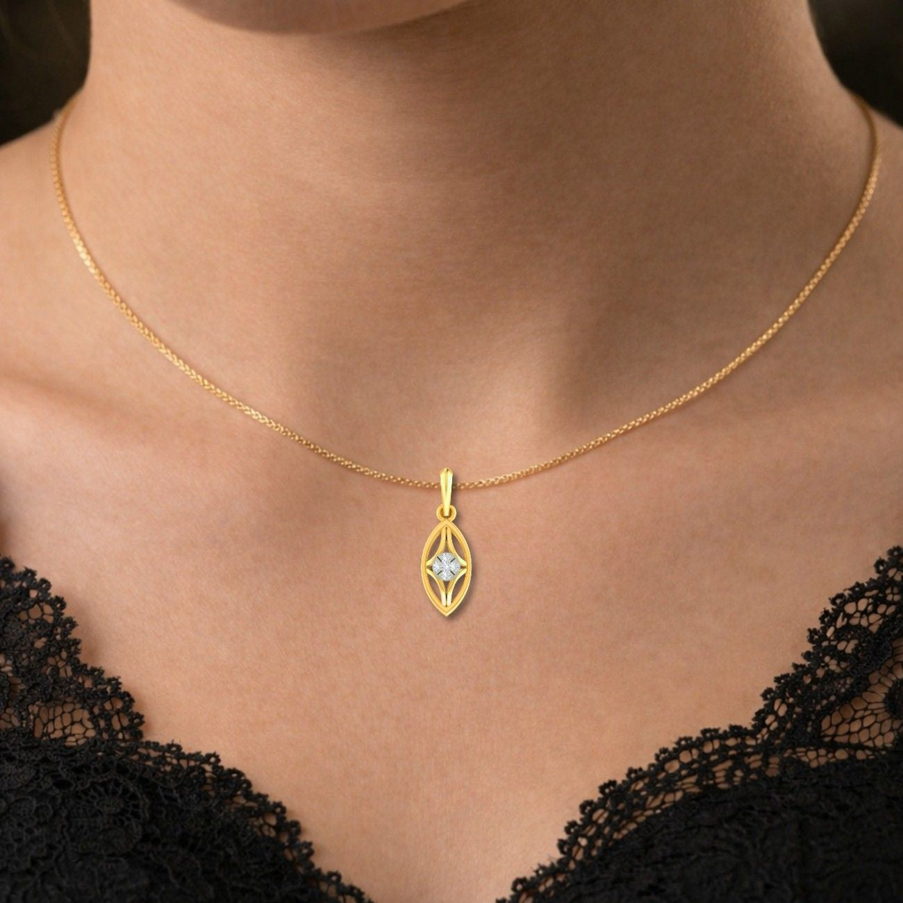 Gold necklace with a pendant on a person wearing a black lace top.