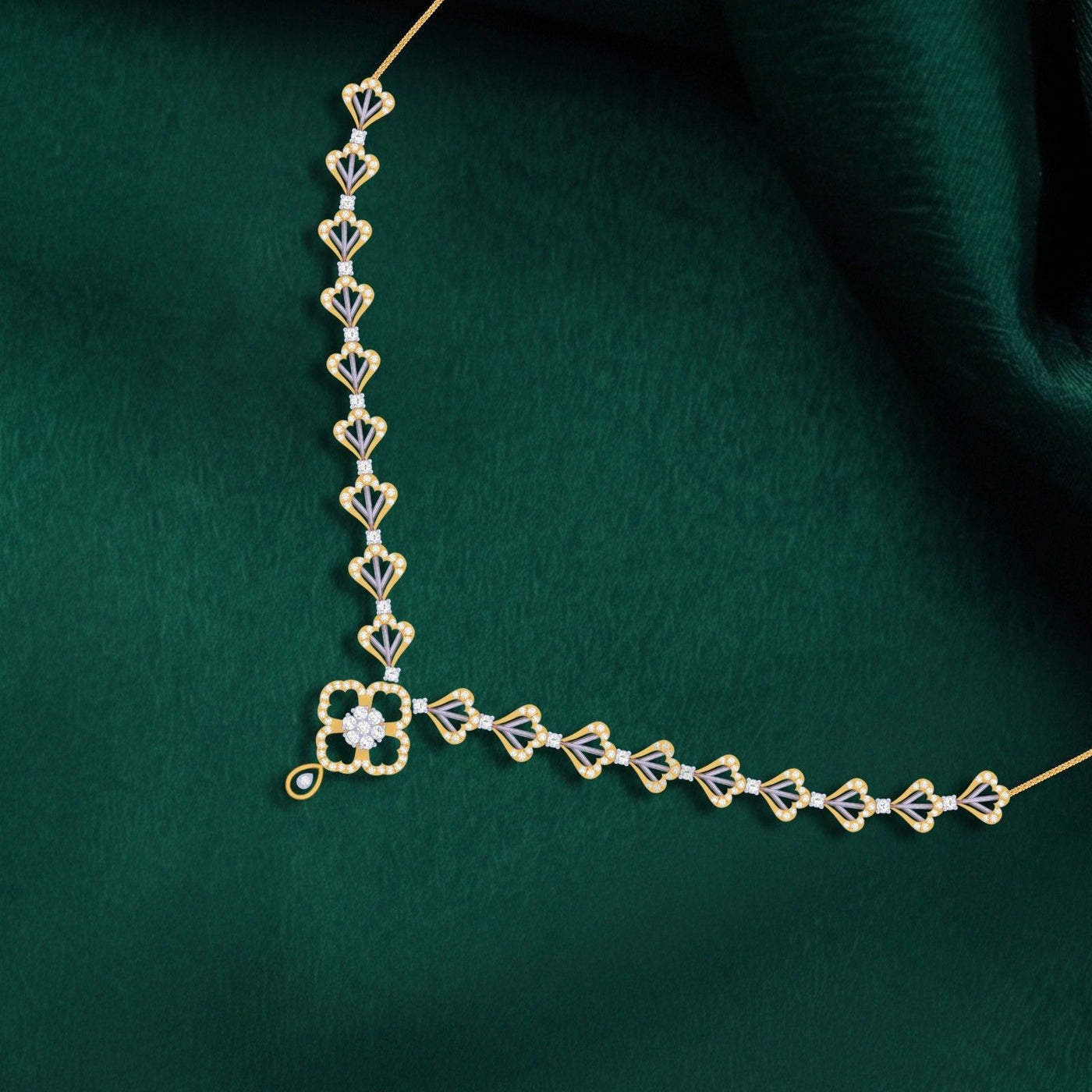 Gold necklace with diamond accents on a green fabric background.